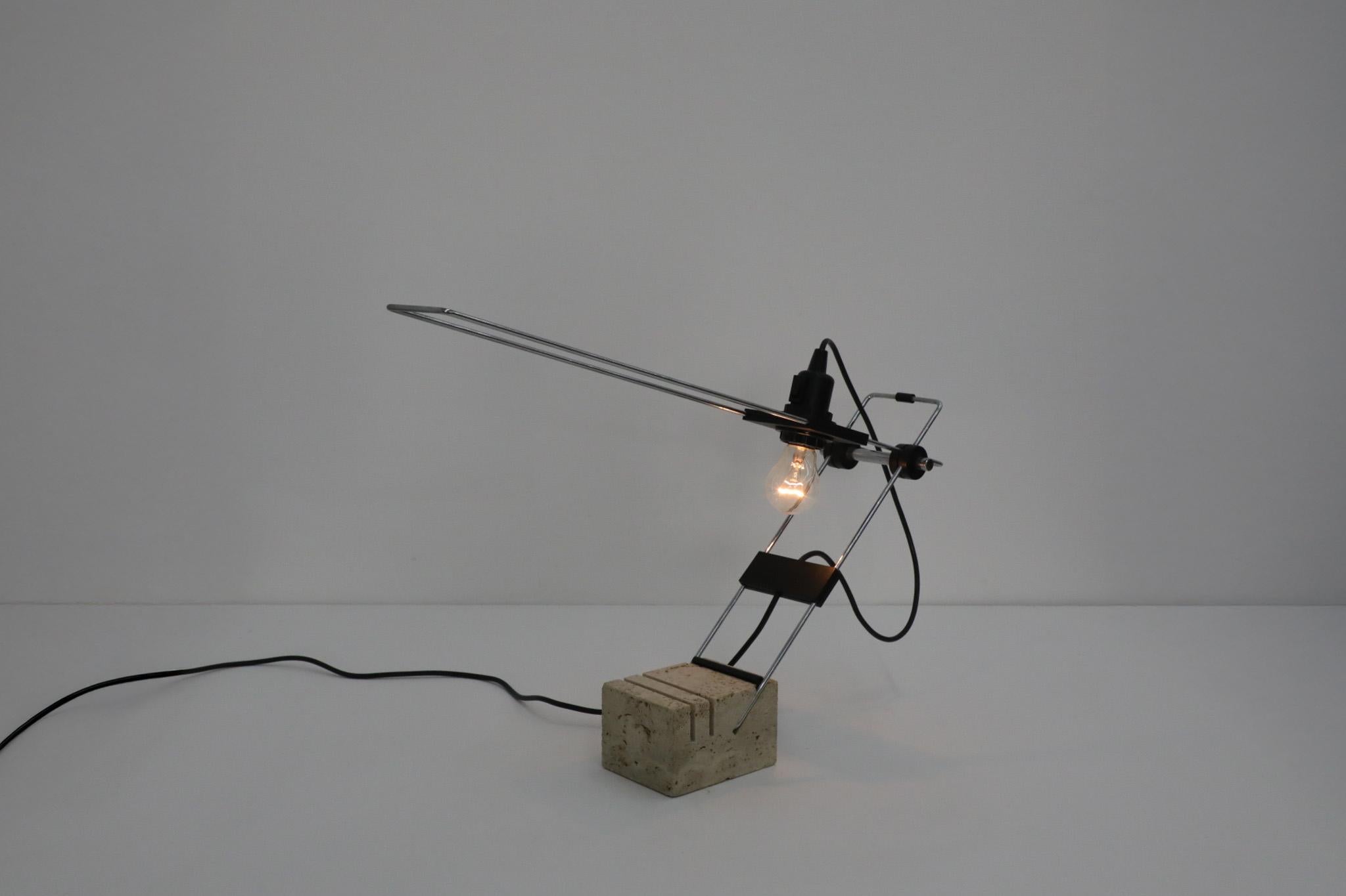 Beautiful Italian table lamp designed by Fratelli Mannelli in the 1970s. Features a beautiful Travertine base with chrome and black hardware. The light can be raised and lowered via an elbow connection and the bulb can slide up and down the chrome