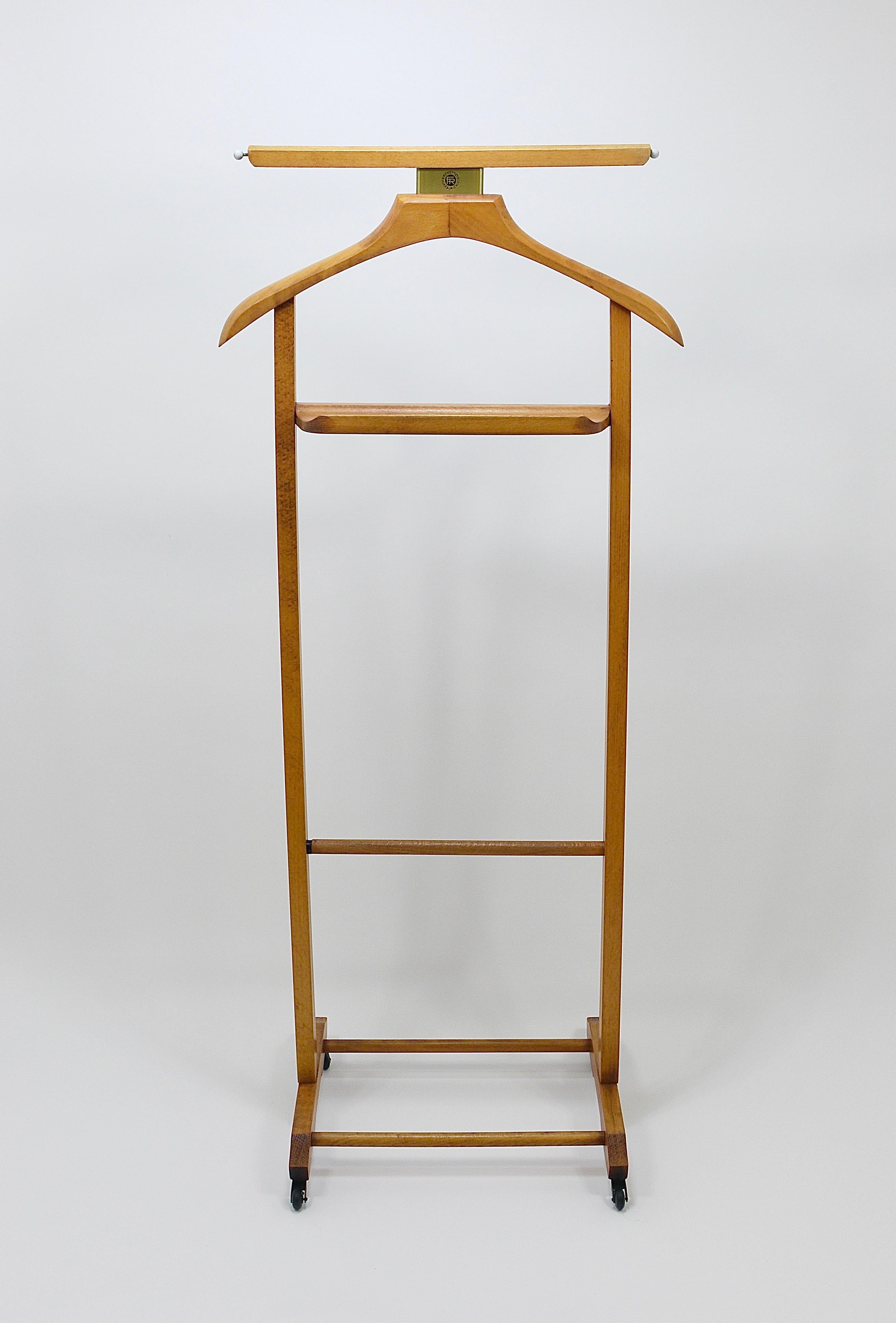 A sculptural Modernist valet clothing stand for both ladies and gentlemen, dating from the 1950s, in the style of Ico & Luisa Parisi. Executed by Fratelli Reguitti, Italy. Crafted from beech wood in a medium brown color, it features an elegant satin