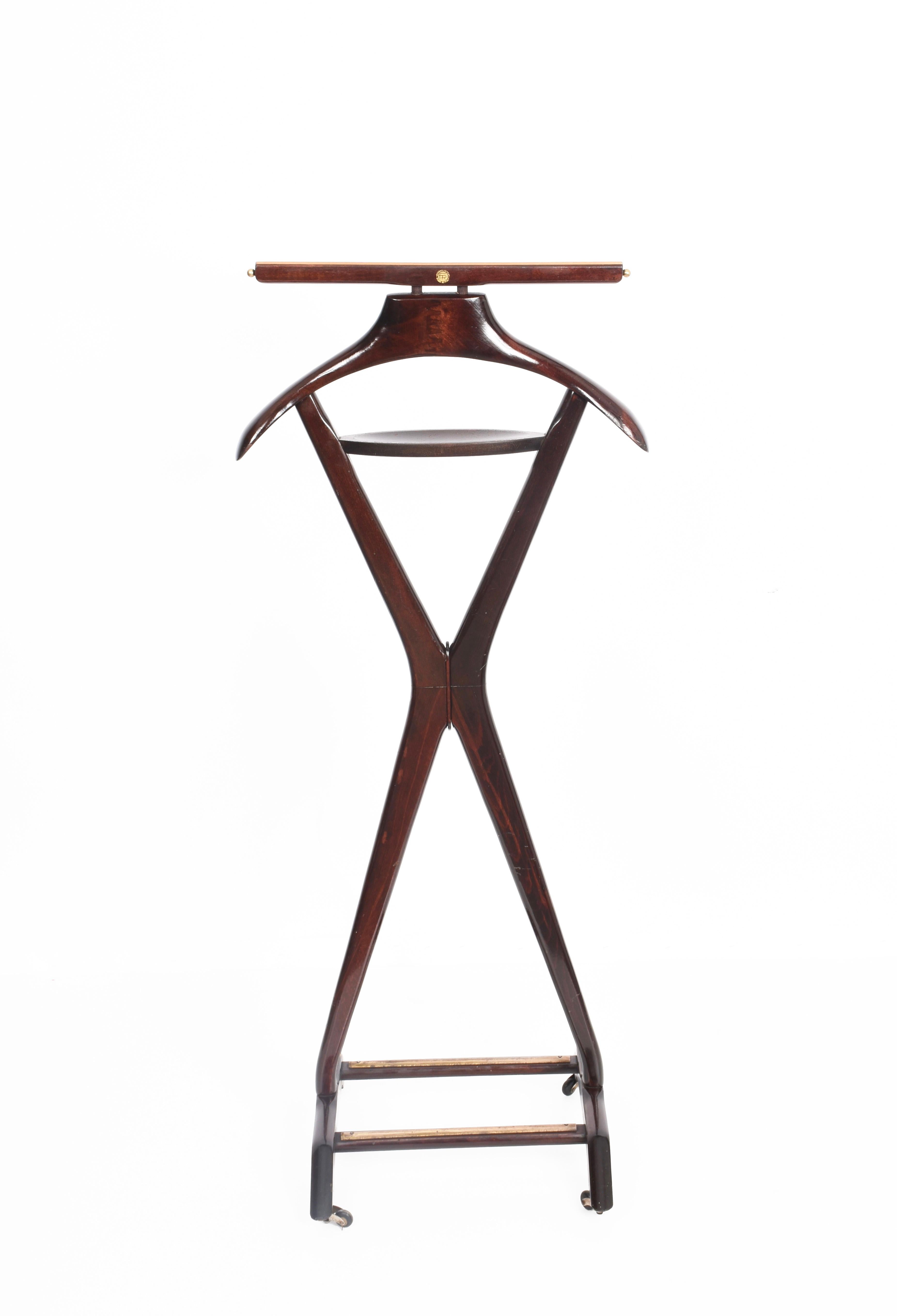 Extremely rare midcentury valet stand in beech and brass. This wonderful item was produced in the 1950s by the Reguitti Brothers in Italy.

This very rare coat rack is made of stained beechwood with a unique midcentury design with an intriguing