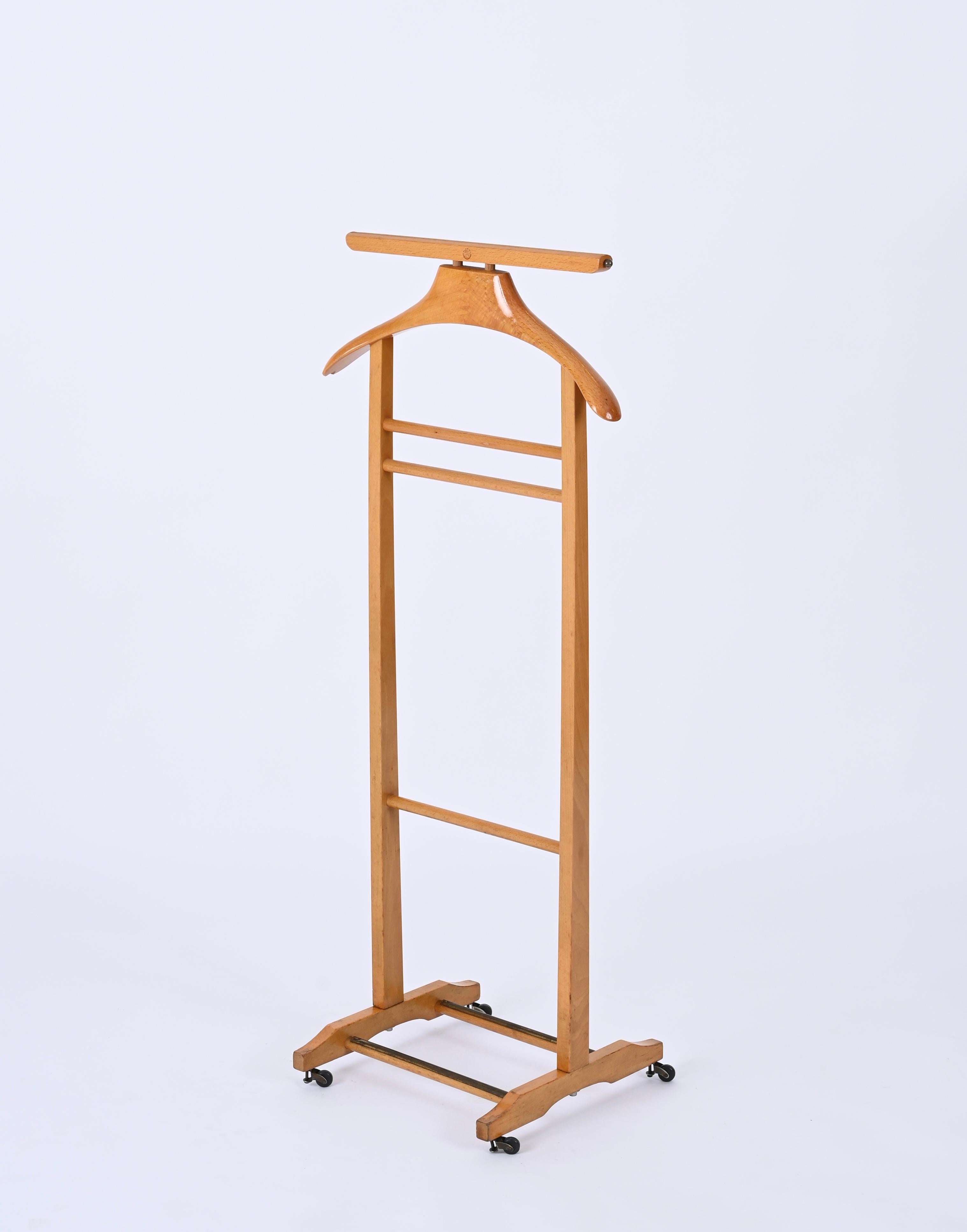 Very rare midcentury valet stand in a stunning beechwood and brass. This gorgeous item was produced during the 1950s by the Reguitti Brothers in Italy.

This unique coat rack is made of beechwood and features two solid brass hooks for belts or ties.