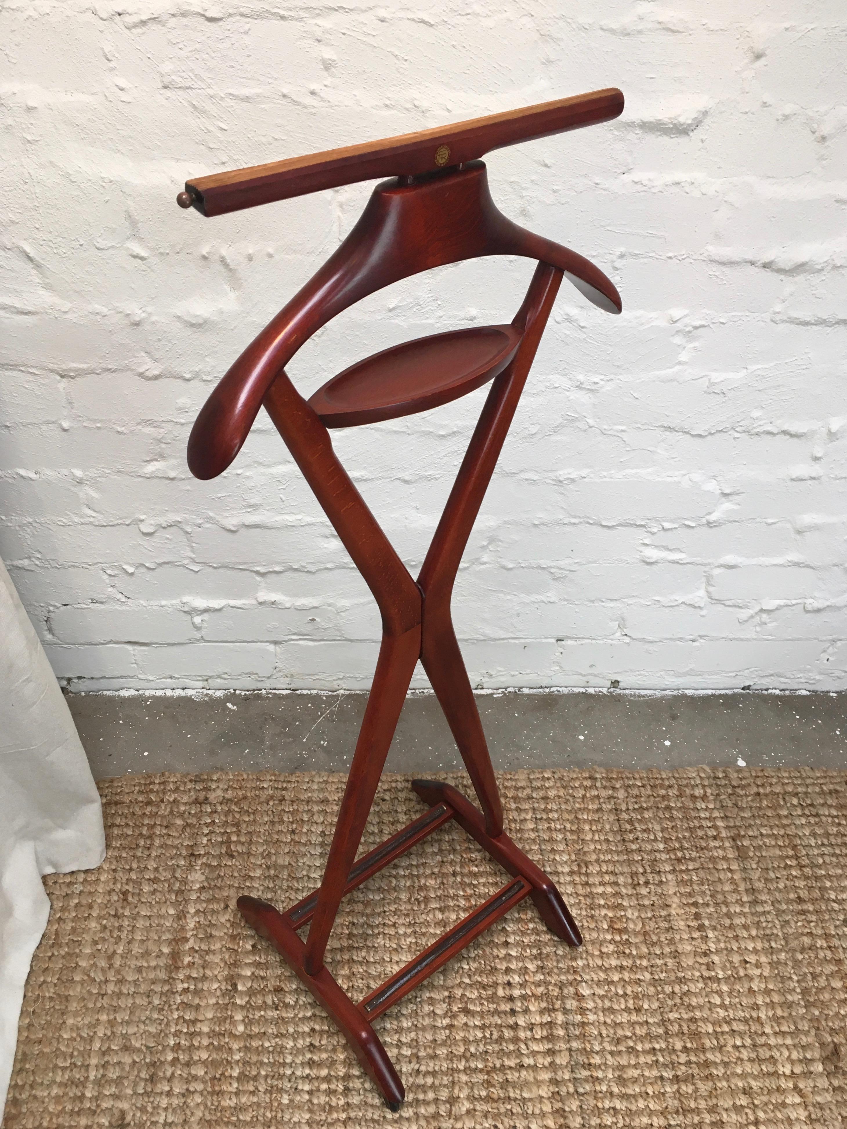 This Fratelli Reguitti X-form valet, in the style of Ico and Luisa Parisi, is in exceptionally good condition.

It features a lovely, rich mahogany stained beech timber frame, brass hardware and rubber wheels. The whole unit is tight and solid,