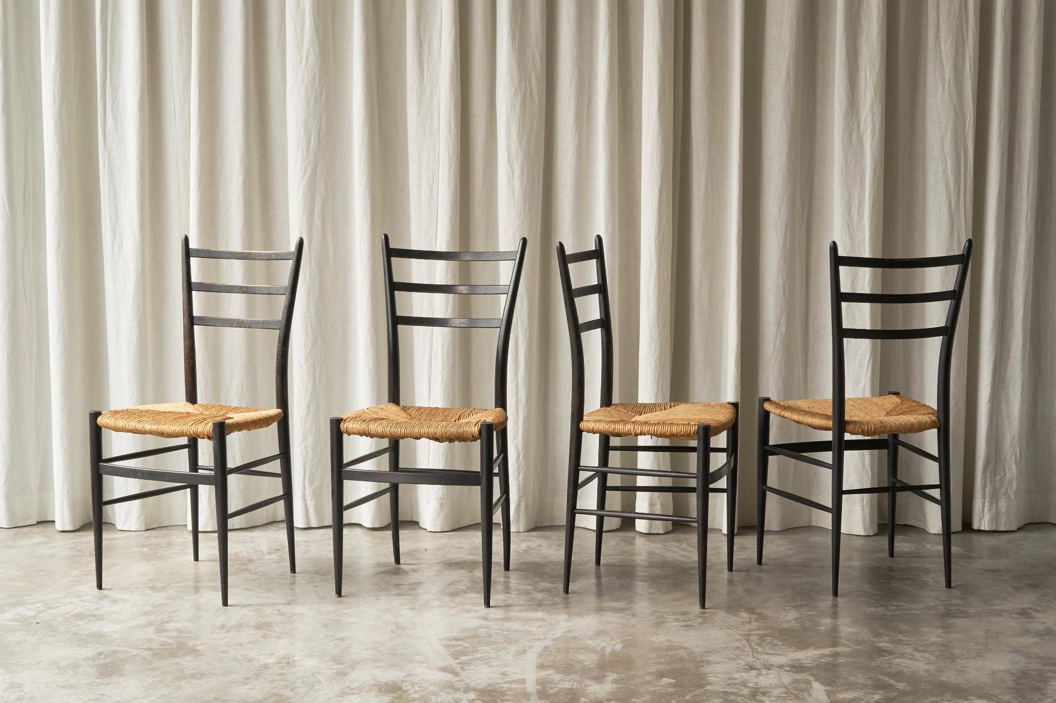 Fratelli Spinetto Chiavari Satz von 4 Esszimmerstühlen aus ebonisiertem Holz und Stroh, Italien, 1950er Jahre.

Ein sehr elegantes und minimalistisches Stuhlset, das ganz im Zeichen der Jahrhundertmitte steht. Ein großartiges Design. Diese Stühle