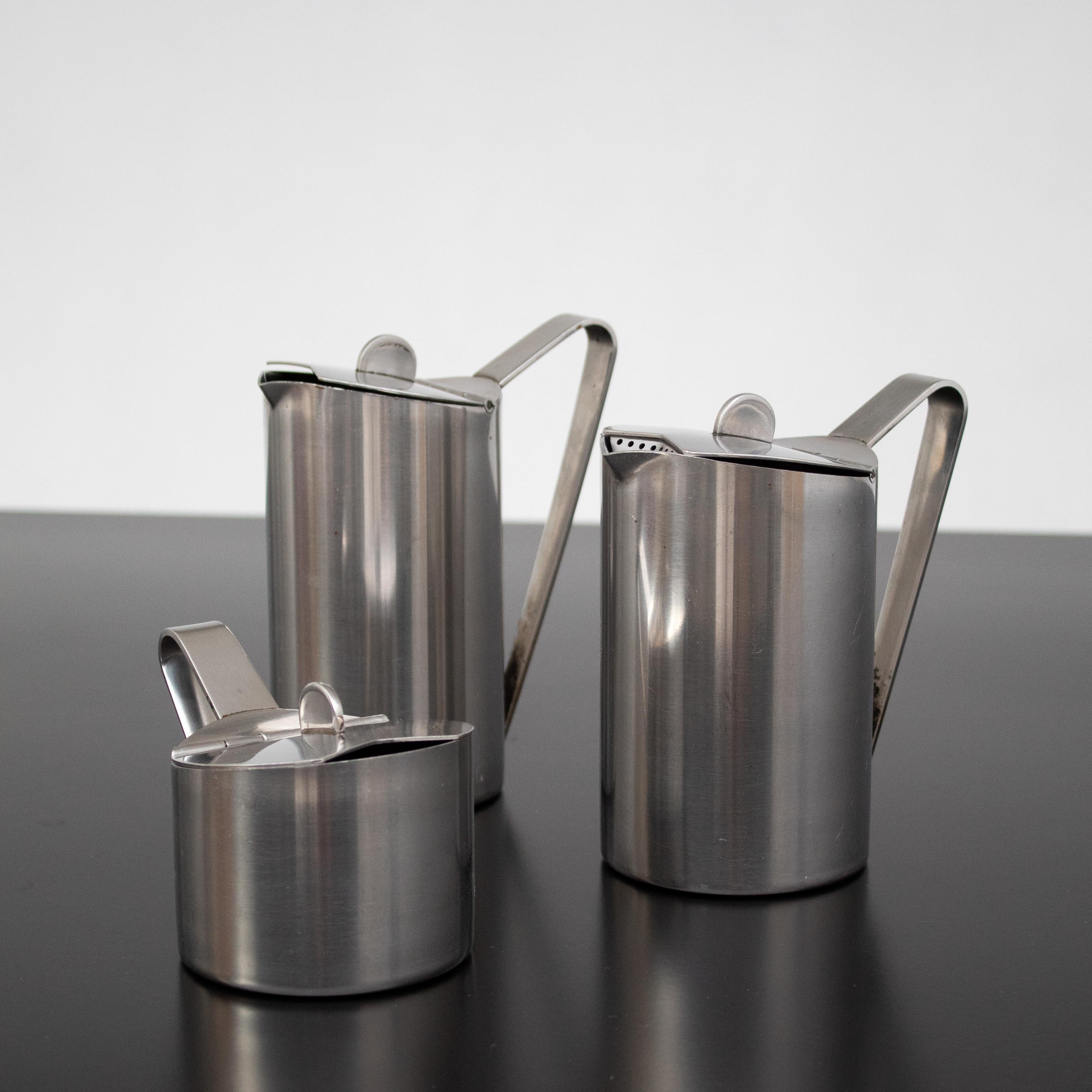 Ce service à thé vintage Fratelli en acier inoxydable allie un design élégant à une fonctionnalité quotidienne. Fabriqué en Italie, l'ensemble comprend une théière, un pot à lait et un sucrier, tous fabriqués en acier inoxydable brossé de haute