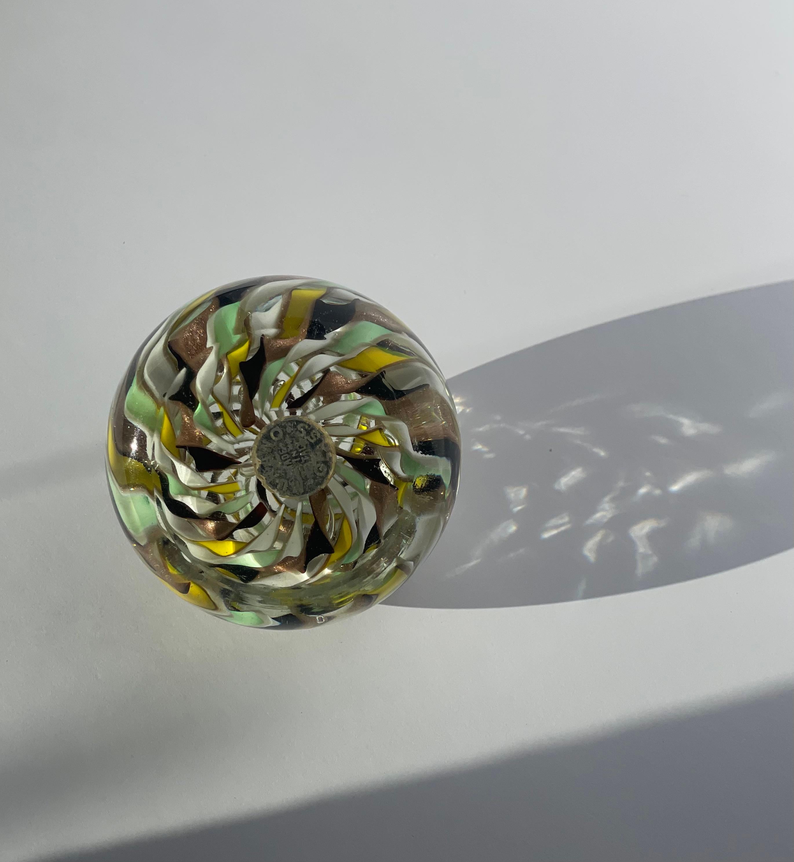 Aggiungi un po' di magia Mid-Century alla tua scrivania o alla tua esposizione con questo splendido fermacarte in vetro di Murano di Fratelli Toso, realizzato in Italia negli anni '50. Questa bellezza sferica presenta un intricato motivo a vortice