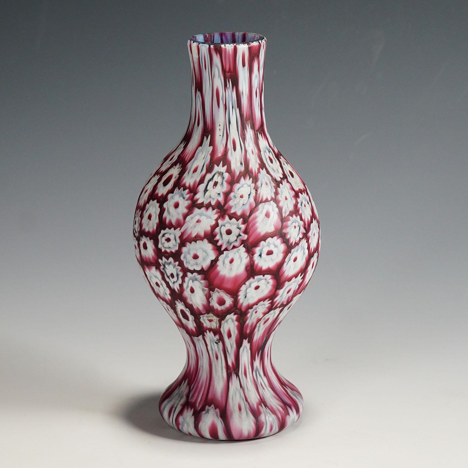 Un très beau vase en verre murrine, fabriqué par Vetreria Fratelli Toso au début du 20e siècle. Le vase est exécuté avec des millefiori polychromes rouges et blancs disposés en rangées verticales sur un corps en verre bleu. Un exemple authentique de