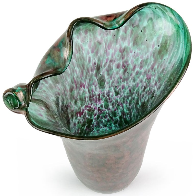 Beautiful large vintage Murano hand blown amethyst spots over green, and aventurine flecks Italian art glass flower vase. Documented to the Fratelli Toso Company. The piece has a pinched rim, with scroll decoration. Profusely covered in copper