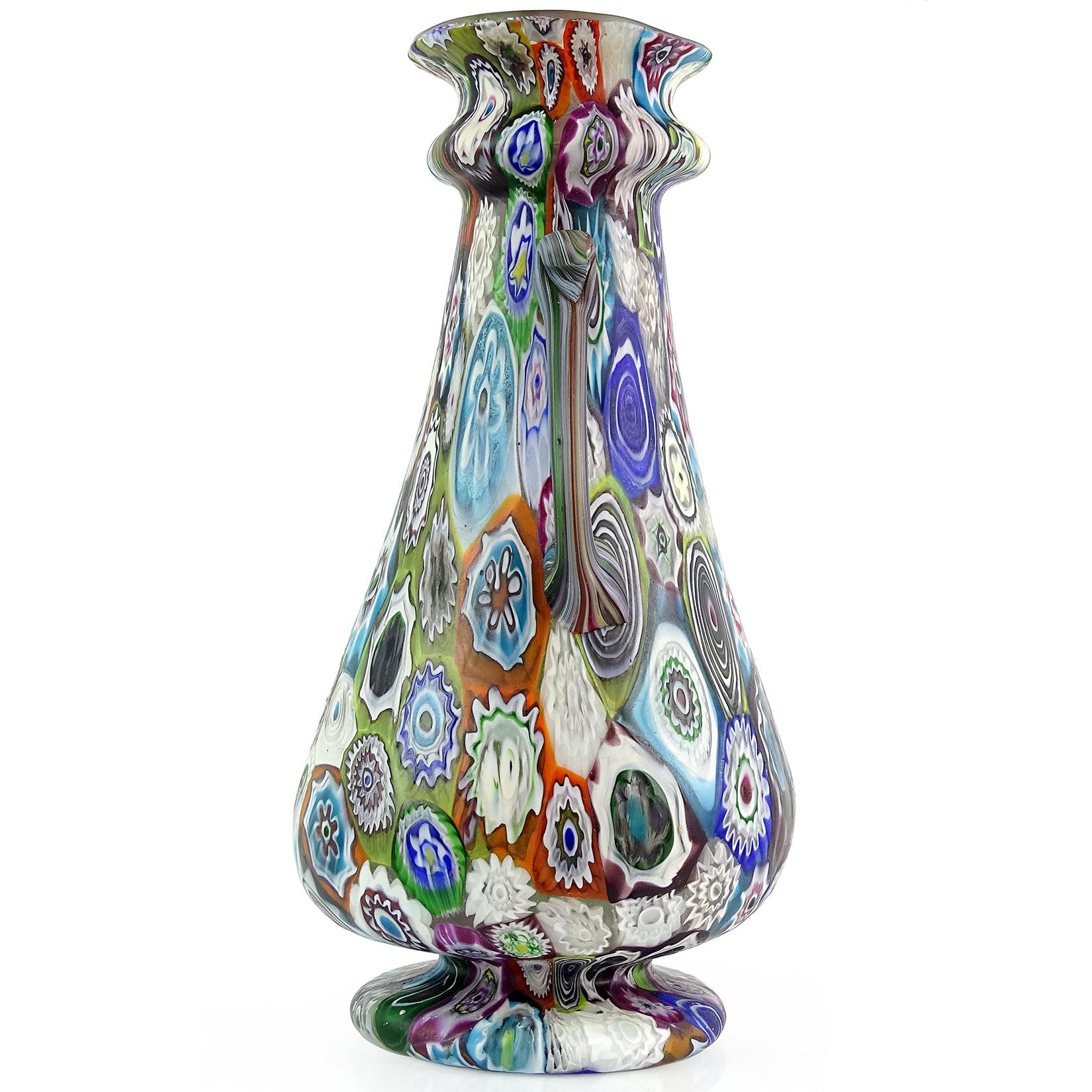 Beautiful, and large, antique Murano hand blown Millefiori Murrina flower mosaic Italian art glass decorative flower vase. Documented to the Fratelli Toso company, circa 1900-1920. The vase has a flared rim, with 2 ornate handles on the sides. It