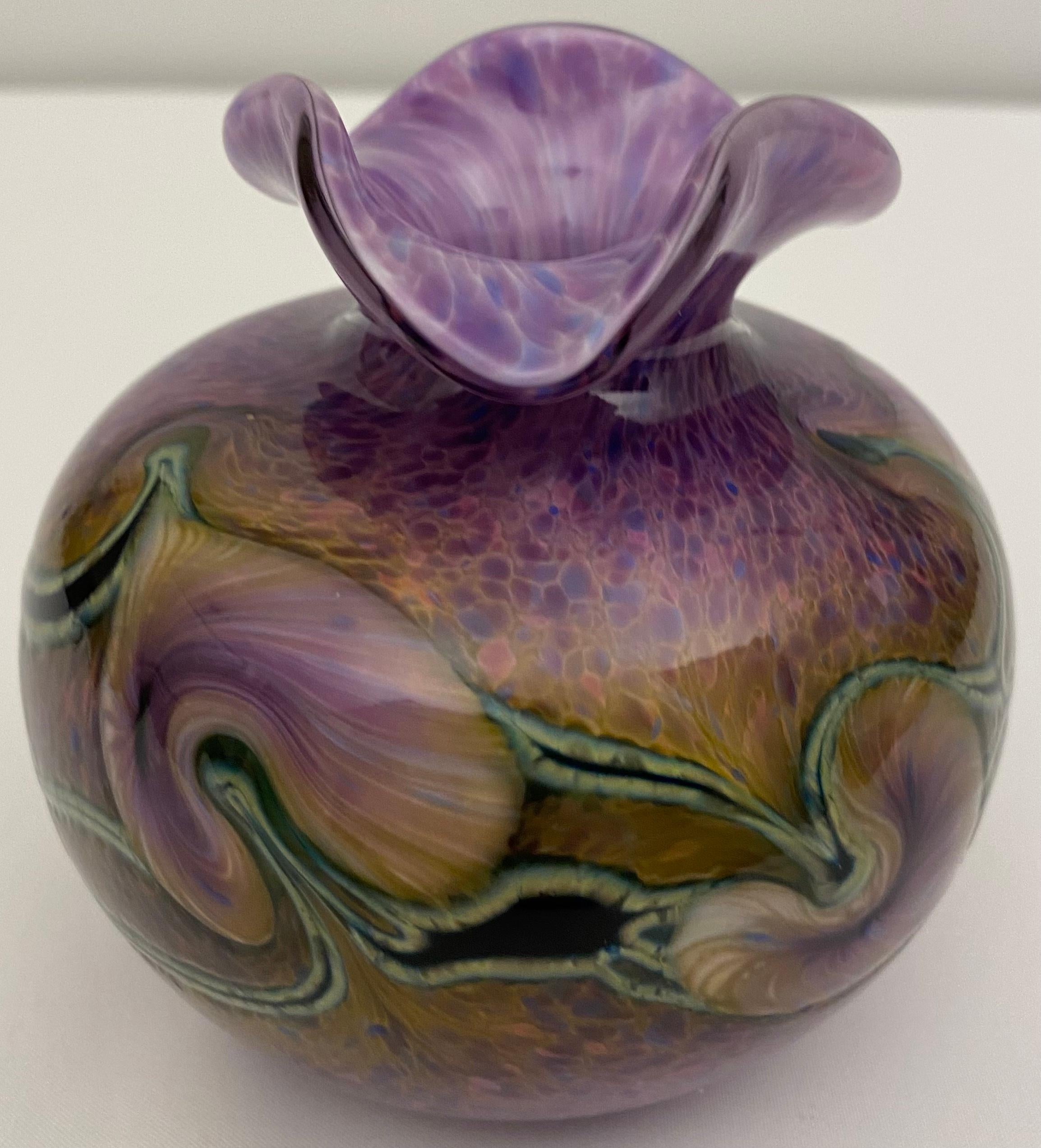 Schöne runde Vase aus Murano-Glas. Oben sind die Ränder wellenförmig nach außen gewölbt. Die Basis ist weiß mit kleinen Schattierungen von Lila, Blau und Rosa. Die Farben gehen von dunkleren Farben im unteren Bereich zu etwas helleren Tönen im