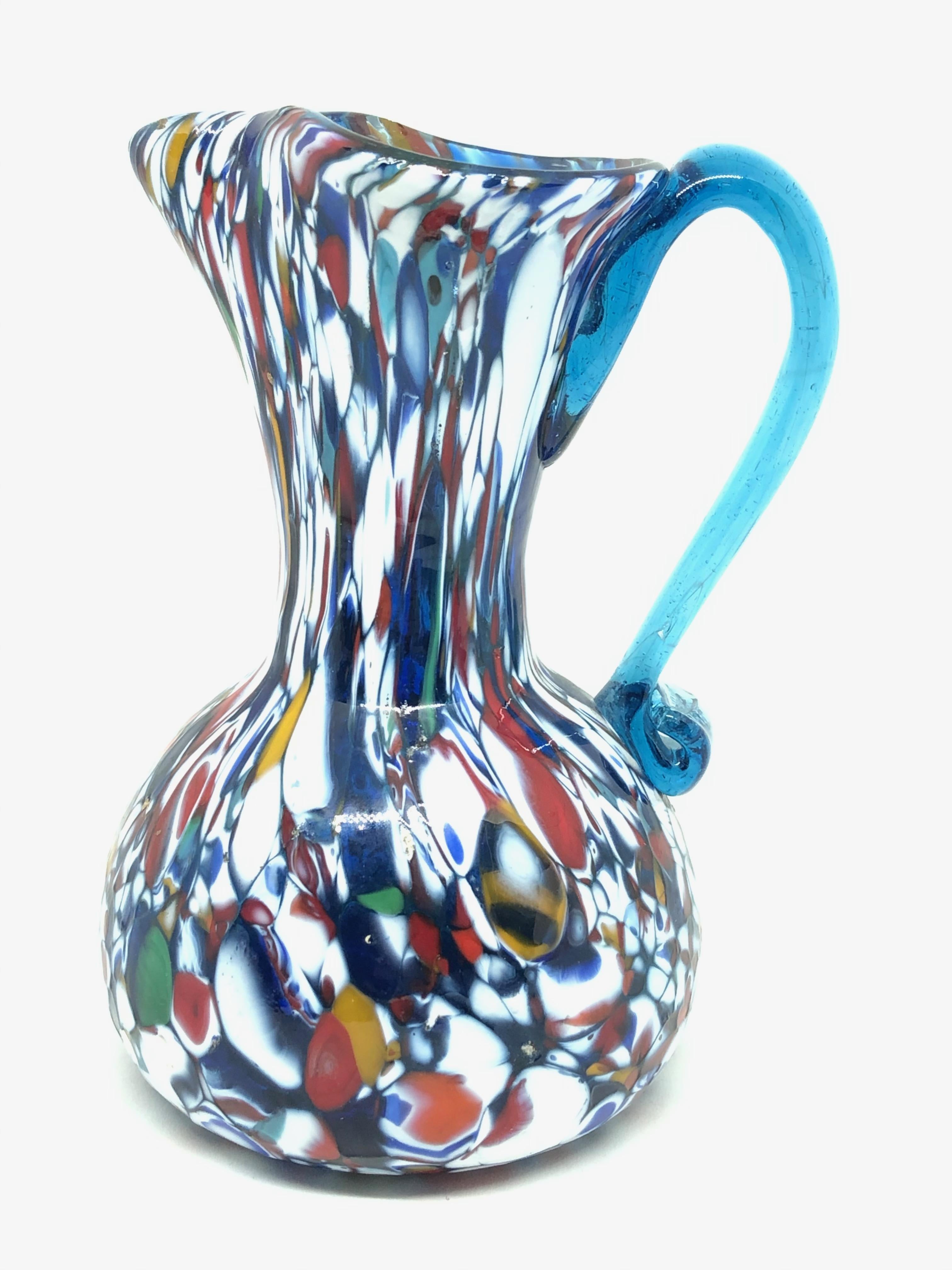 Beautiful Murano hand blown Italian art glass vase. Created by a Fratelli Toso company. Blue core with colorful murine and light blue applied handle. A beautiful piece of art for any room.
