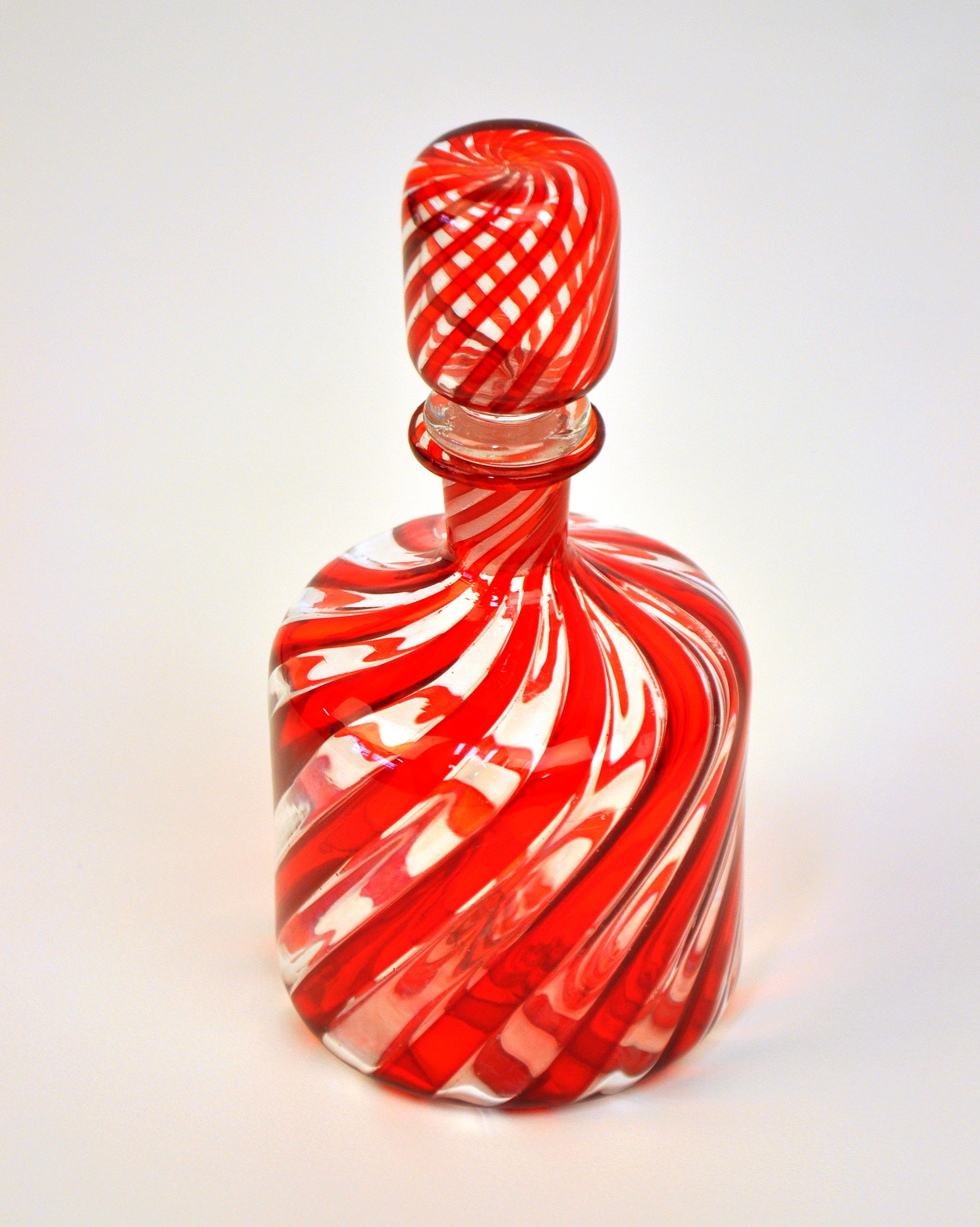 This Mid-Century Modern Venetian art glass small decanter or large perfume bottle features a red and clear swirl pattern. Manufactured by Fratelli Toso, the vintage Italian decorative bottle dates from the 1960s. Simple, elegant and timeless, much