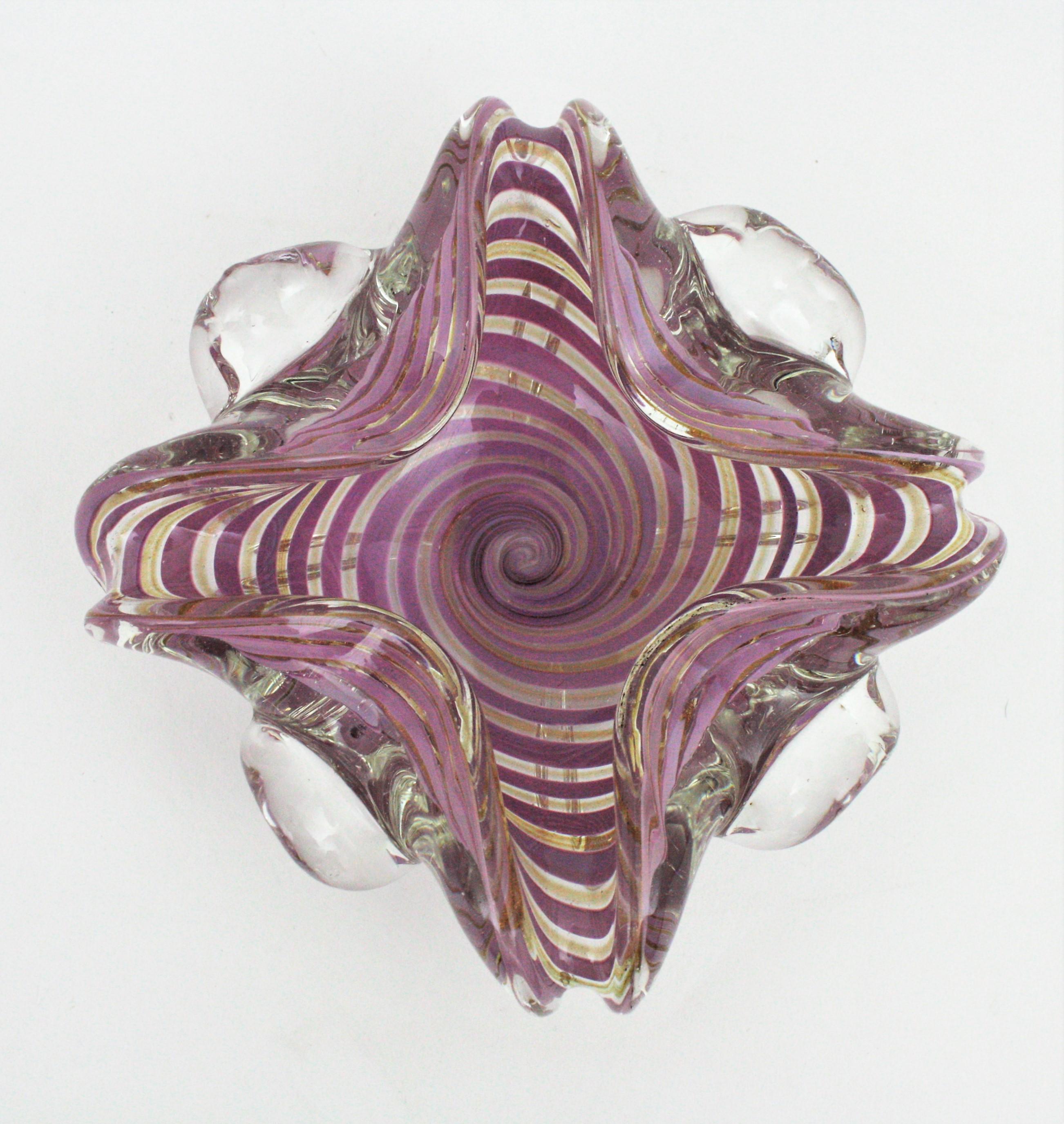 Exquiste hand blown Murano glass Sommerso swirl ribbon large bowl or ashtray with gold dust. Attributed to Fratelli Toso, Italy, 1950s.
This decorative art glass bowl has a cane working twisting ribbons decoration in lilac/purple submerged into