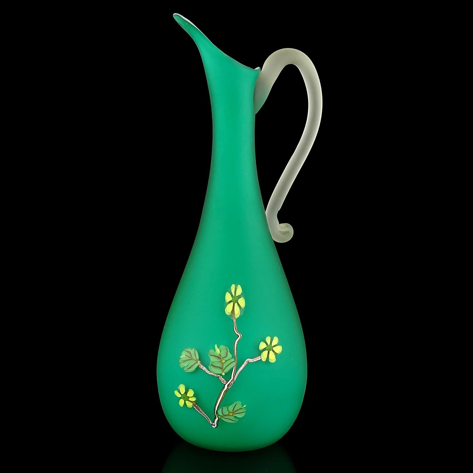 Beautiful Murano hand blown green satin surface Italian art glass ewer vase, with applied millefiori flowers decoration. Documented to the Fratelli Toso company. It is soft to the touch like velvet. It also still retains an original importers label.