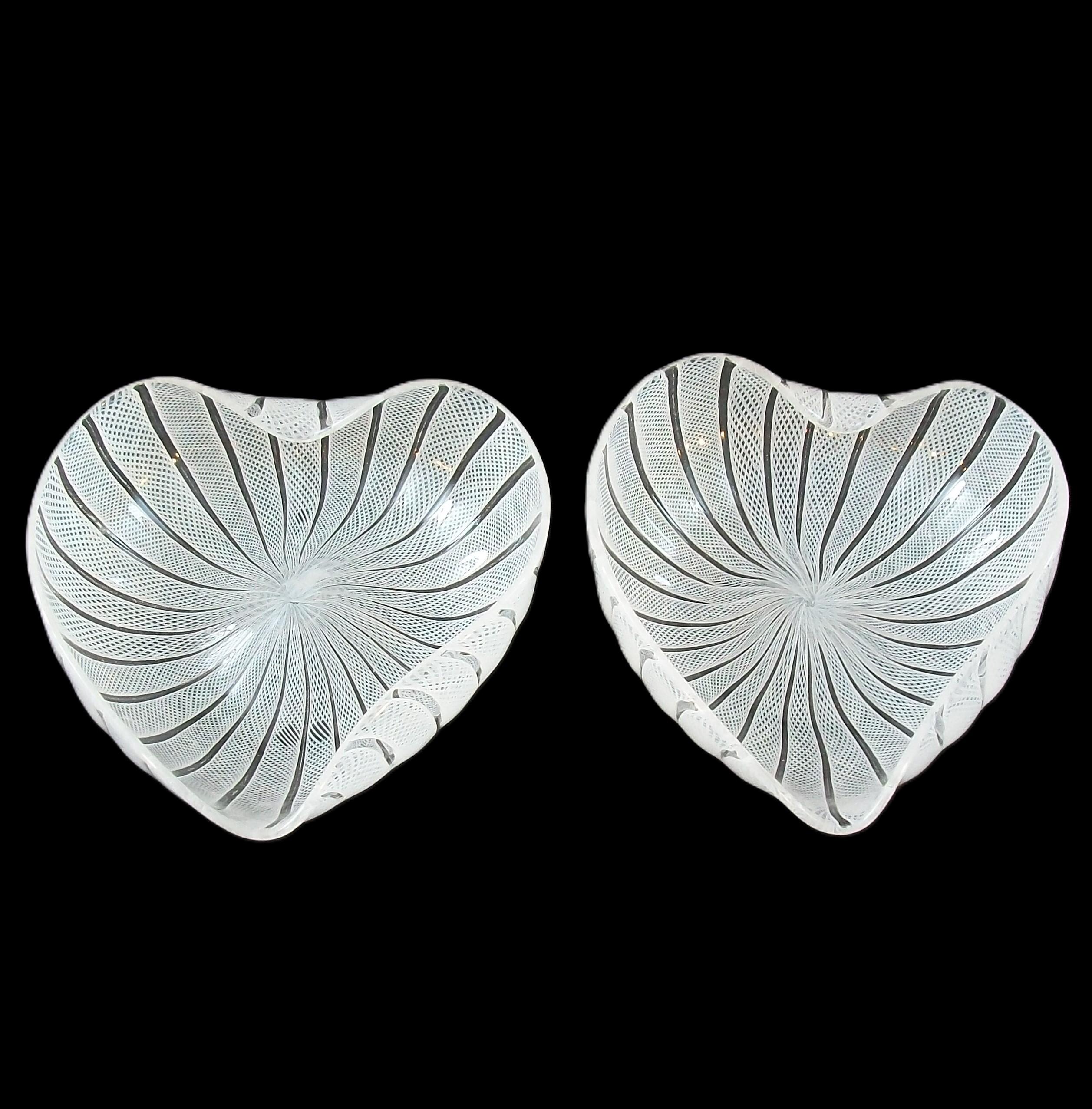 FRATELLI TOSO - Coppia di ciotole a forma di cuore in vetro artistico di Murano della metà del secolo scorso - con canne di latticino bianco - peso leggero e finitura lucida - una con fondo smerigliato - non firmata - Italia - circa anni