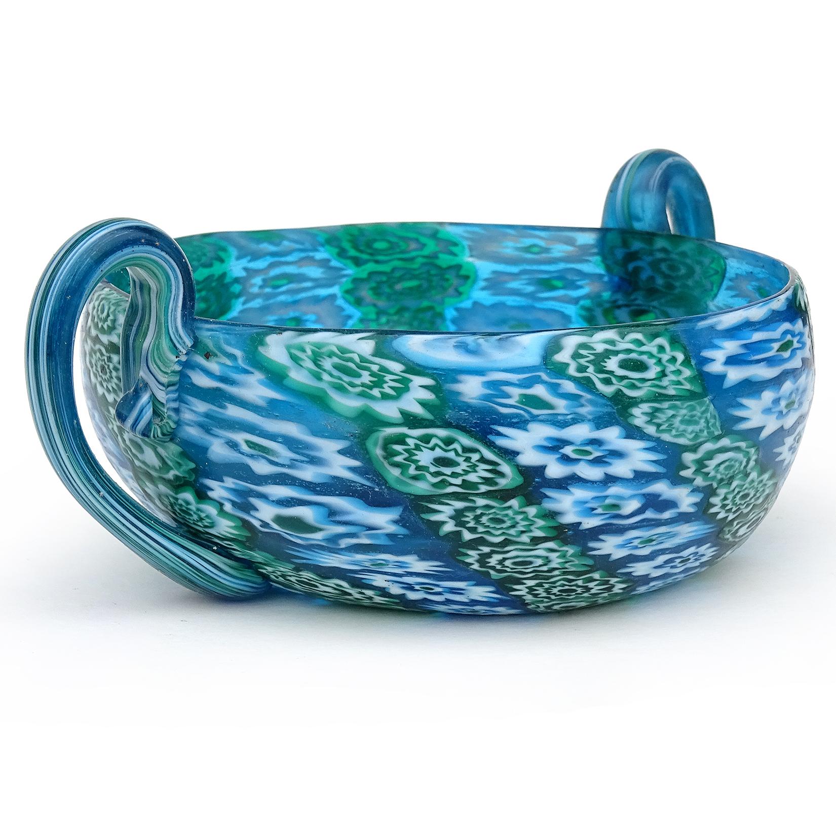 Bellissima ciotola antica di Murano soffiata a mano in vetro artistico italiano a mosaico di fiori di Murano blu, verde e bianco. Documentato alla ditta Fratelli Toso, circa 1900-1920. La ciotola ha un design a doppio manico, con il centro smussato.