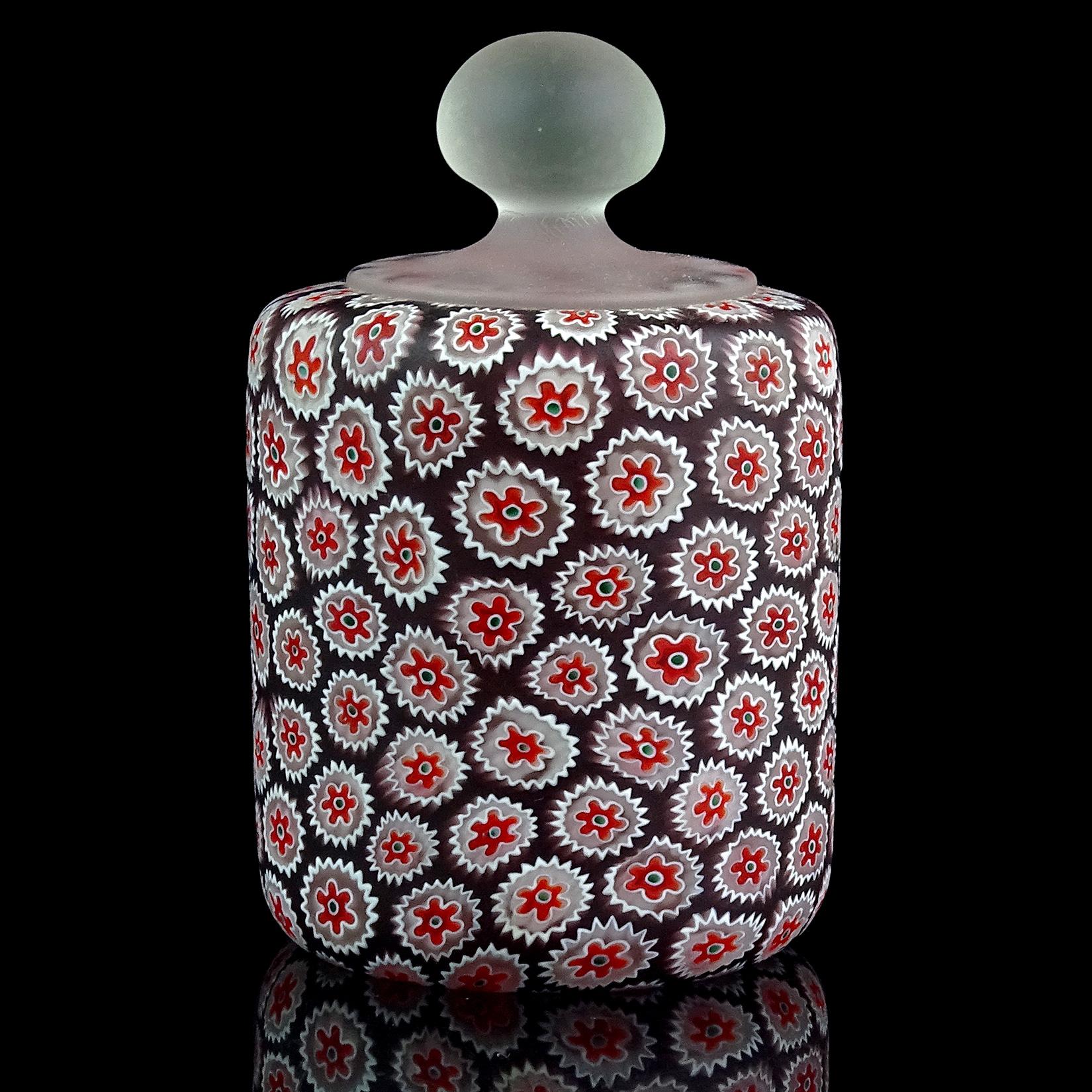 Beautiful Murano hand blown millefiori white red flower mosaic and dark purple Italian art glass paperweight. Documented to the Fratelli Toso company. It has a clear handle at the top, with satin surface. Measures: 4 1/2