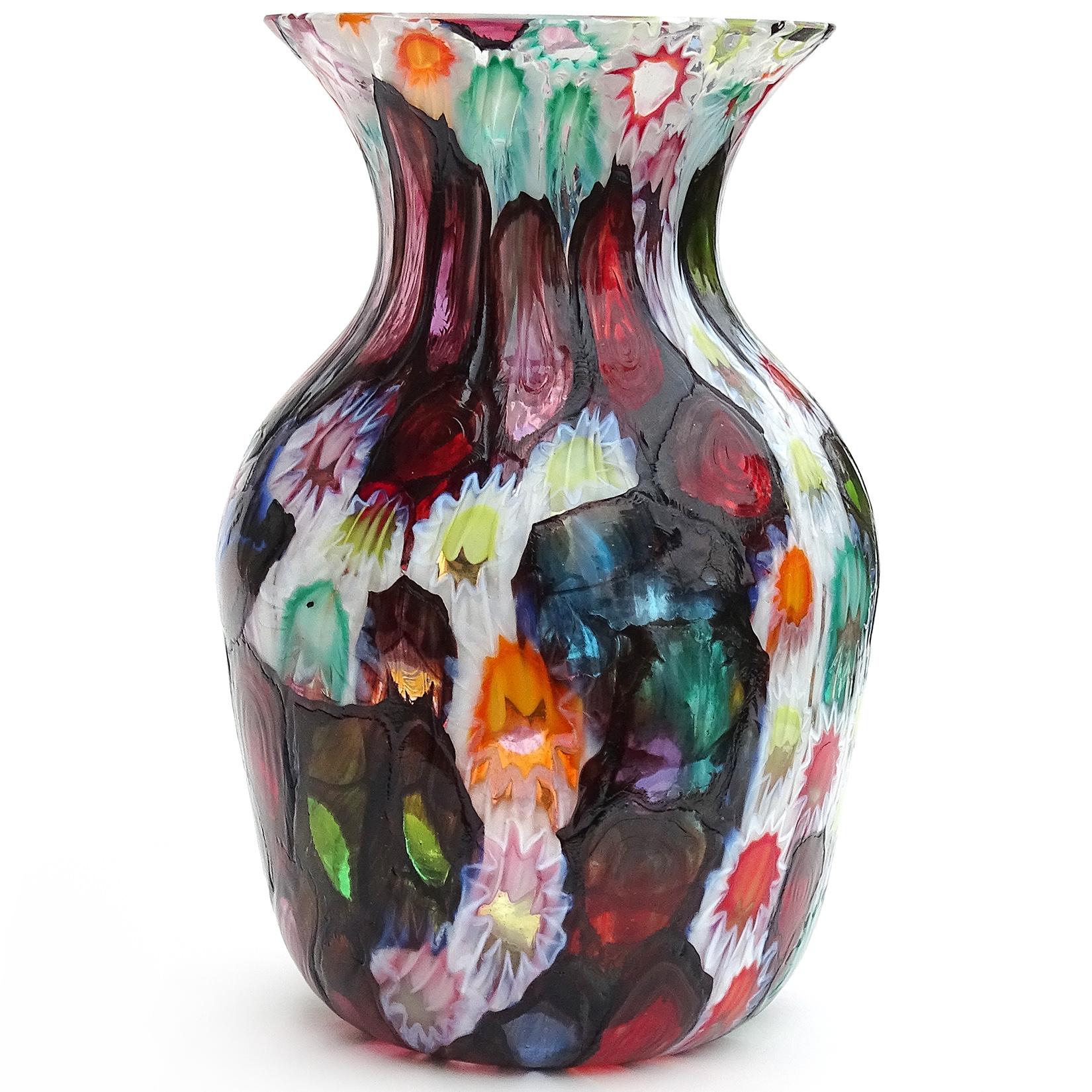 Beautiful Murano hand blown multi-color Millefiori flowers or stars mosaic Italian art glass flower vase. Documented to the Fratelli Toso company. Many of the murrines are lined in metallic black, like stained glass windows. Has blue, red, pink,