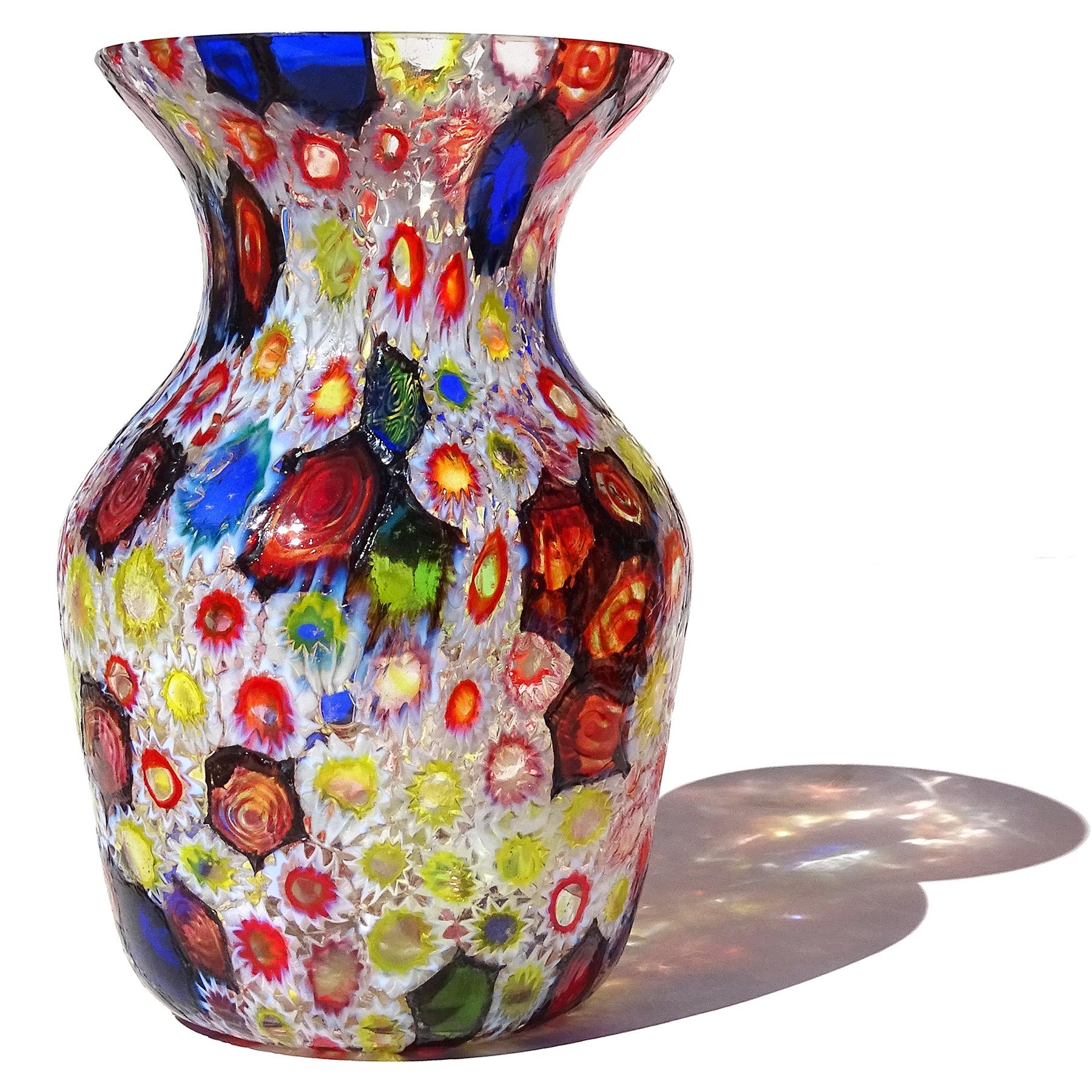 Beautiful vintage Murano hand blown multi-color Millefiori Murrina flower and star mosaic Italian art glass vase. Documented to the Fratelli Toso Company. The vase has a large mouth with flared rim. Many of the murrines are lined in opal white, and