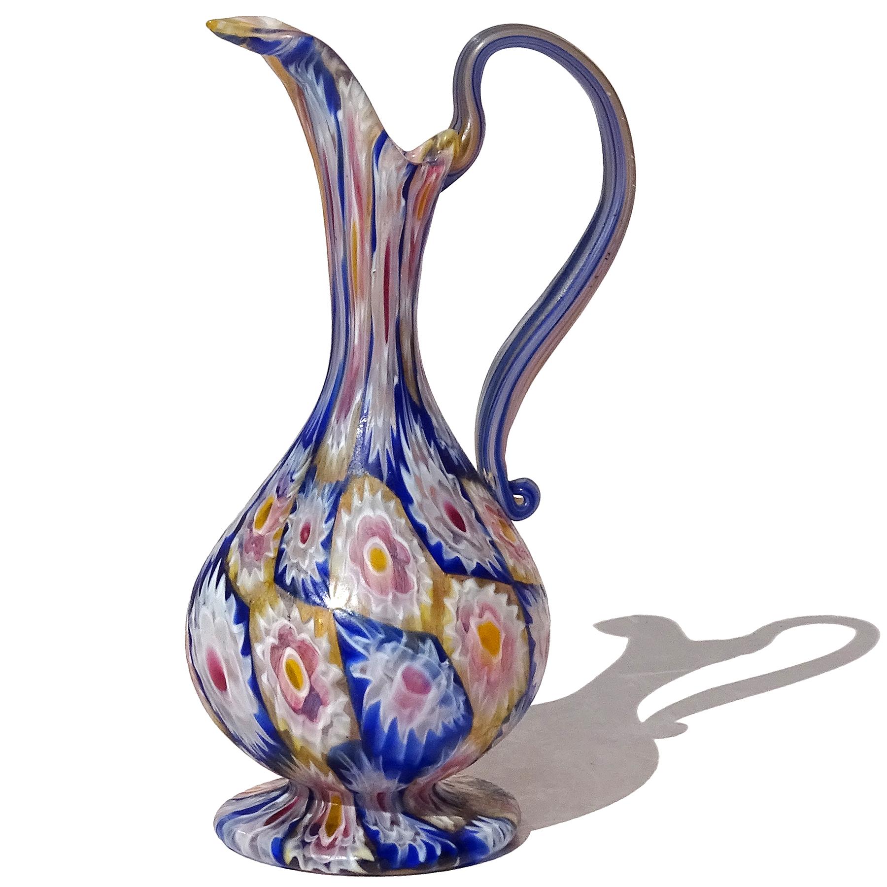 Magnifique vase / pichet antique en verre soufflé à la main de Murano, mosaïque de fleurs Millefiori Murrina, en verre d'art décoratif italien. Documenté à la société Fratelli Toso, vers 1910-1930. La pièce présente un motif en damier, avec des