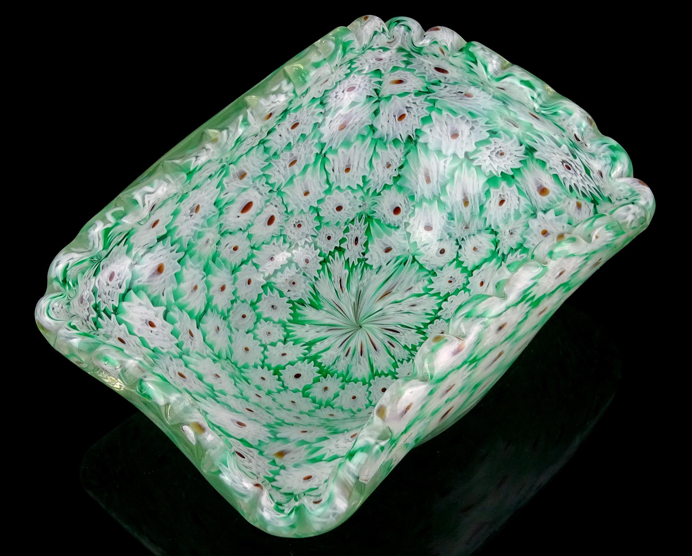 Precioso cuenco decorativo de Murano soplado a mano con mosaico de flores millefiori verdes y blancas. Documentado a la empresa Fratelli Toso. El cuenco tiene forma rectangular, con el borde doblado hacia arriba y festoneado. El fondo del cuenco es