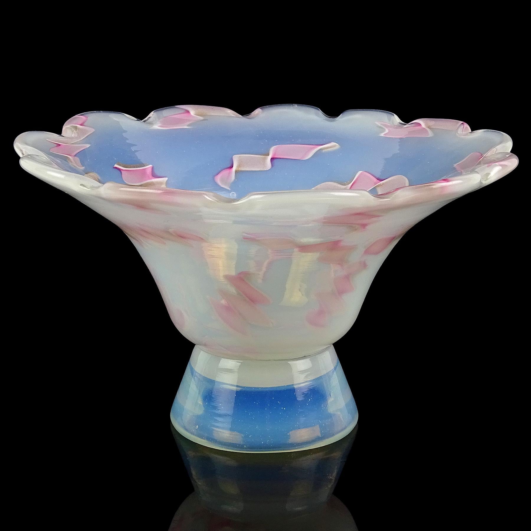 Beautiful vintage Murano hand blown opalescent white and twisted pink ribbons Italian art glass footed bowl. Documented to the Fratelli Toso Company, circa 1956. The bowl has a scalloped flared out rim. The ribbons have glittery copper aventurine