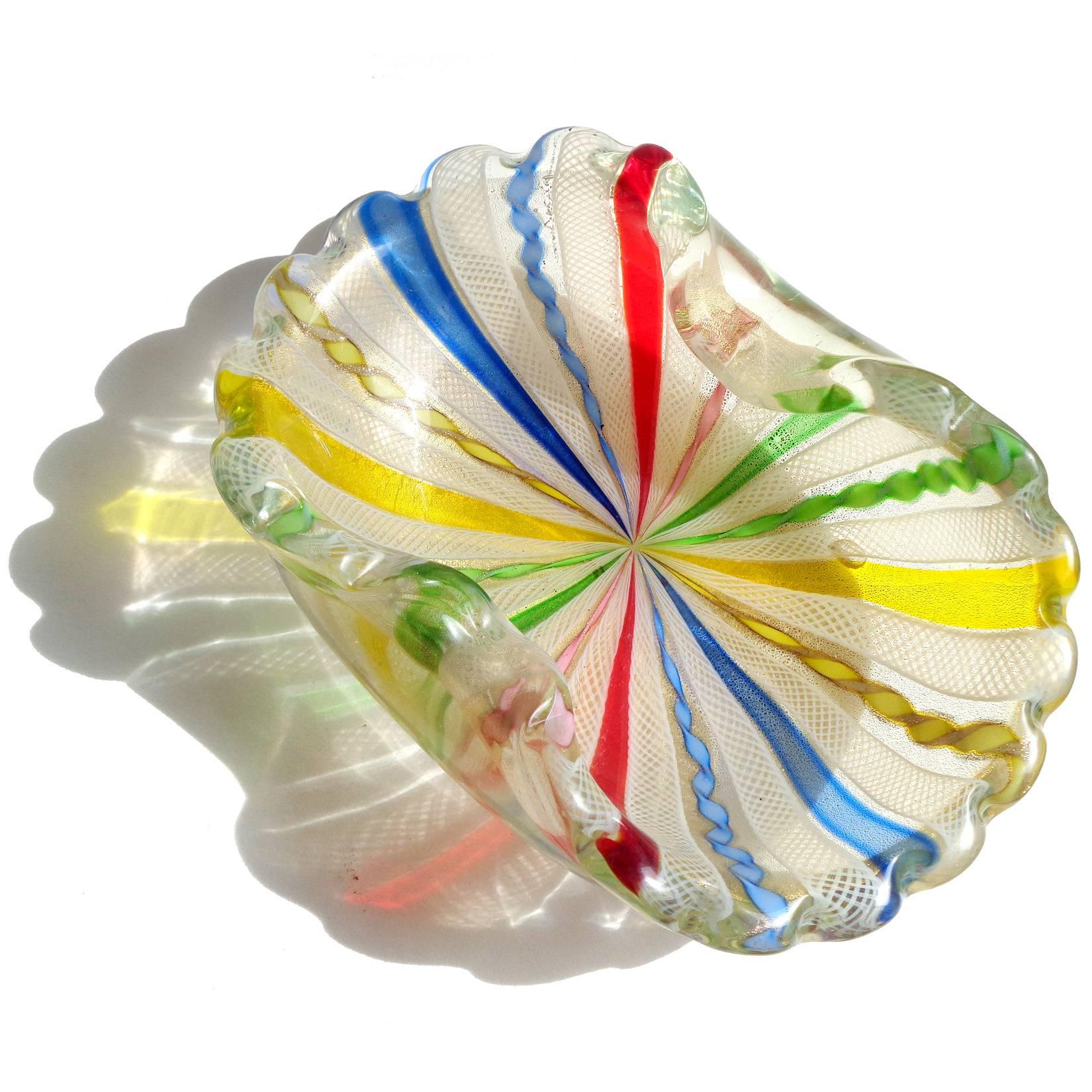 Beautiful large Murano hand blown rainbow ribbons and gold flecks art glass decorative bowl. Documented to the Fratelli Toso Company. The piece has a scalloped rim, Zanfirico, twisted Latticino, and a Canne ribbons. Has red, blue, green, pink,