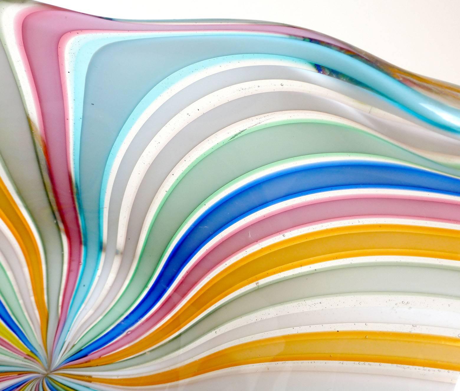 Colorful Murano hand blown rainbow Filigrana ribbons art glass bowl. Documented to designer Fratelli Toso, retaining an intact original label as shown. It has an organic shape, with white, pink, orange, light blue, gray, and green colors. Great