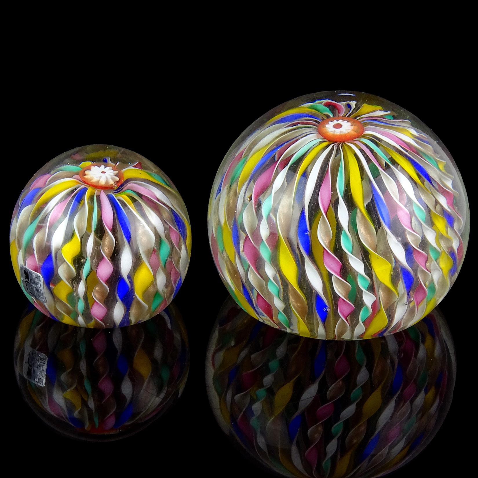 Beautiful Murano hand blown rainbow twisting ribbons, crown murrines, Italian art glass paperweight set. Documented to the Fratelli Toso company. One is an extra large magnum paperweight with matching smaller (normal) paperweight. They have