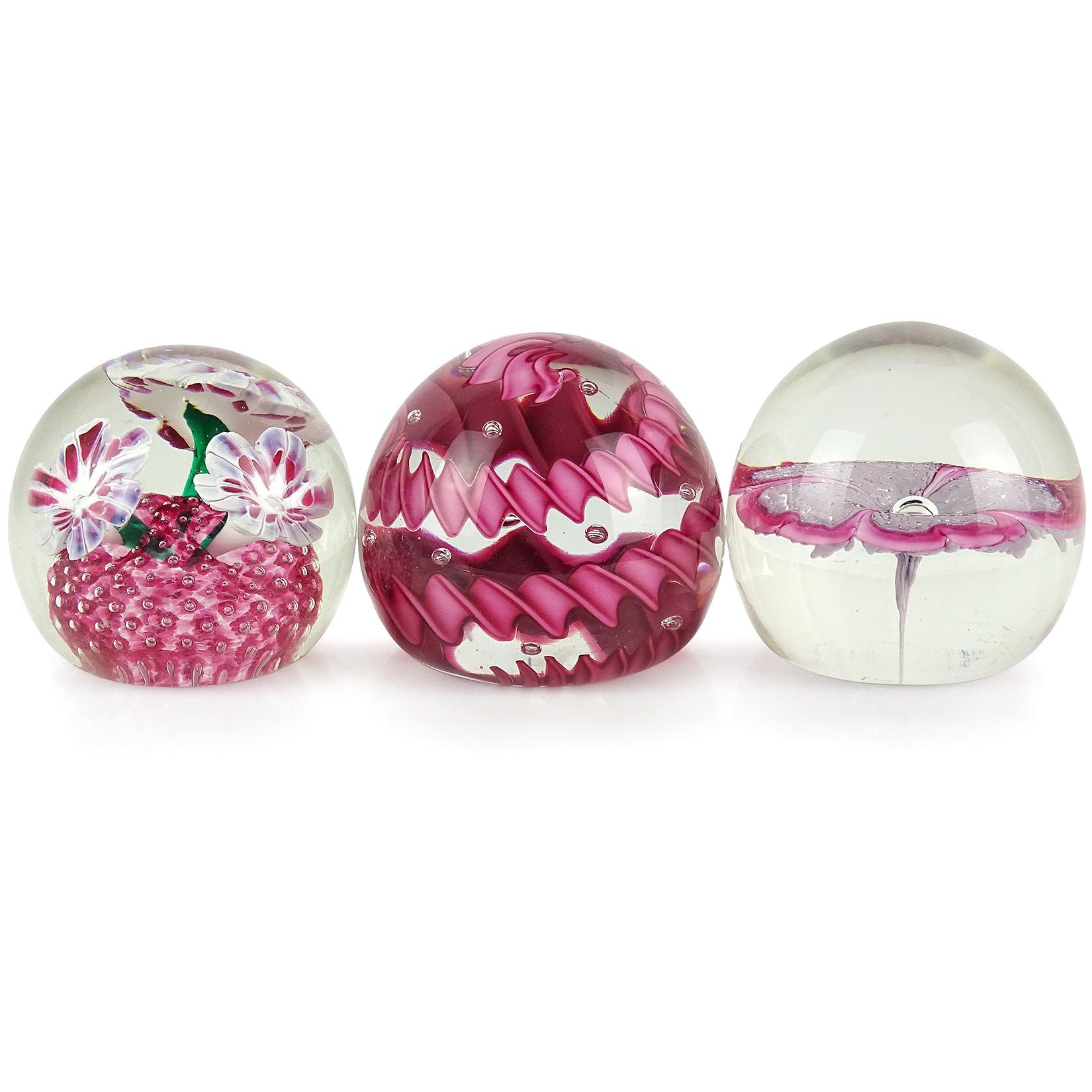Priced per item. Beautiful Murano hand blown Italian art glass paperweights. Documented to the Fratelli Toso company. The first is a deep pink twisted ribbon paperweight, with bubbles in clear glass. Next, a floating lavender flower, with pink edge