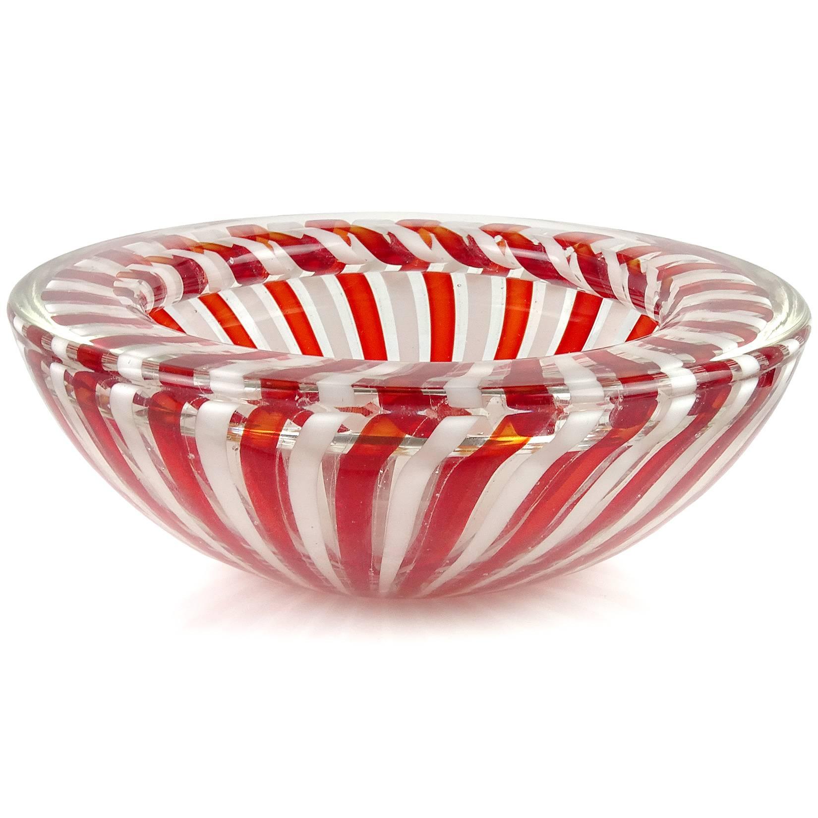 Beautiful Murano hand blown red and white ribbons Italian art glass bowl. Documented to the Fratelli Toso Company. The piece has a folded over rim and pinwheel design. A beautiful statement piece for any table. Measures: 7
