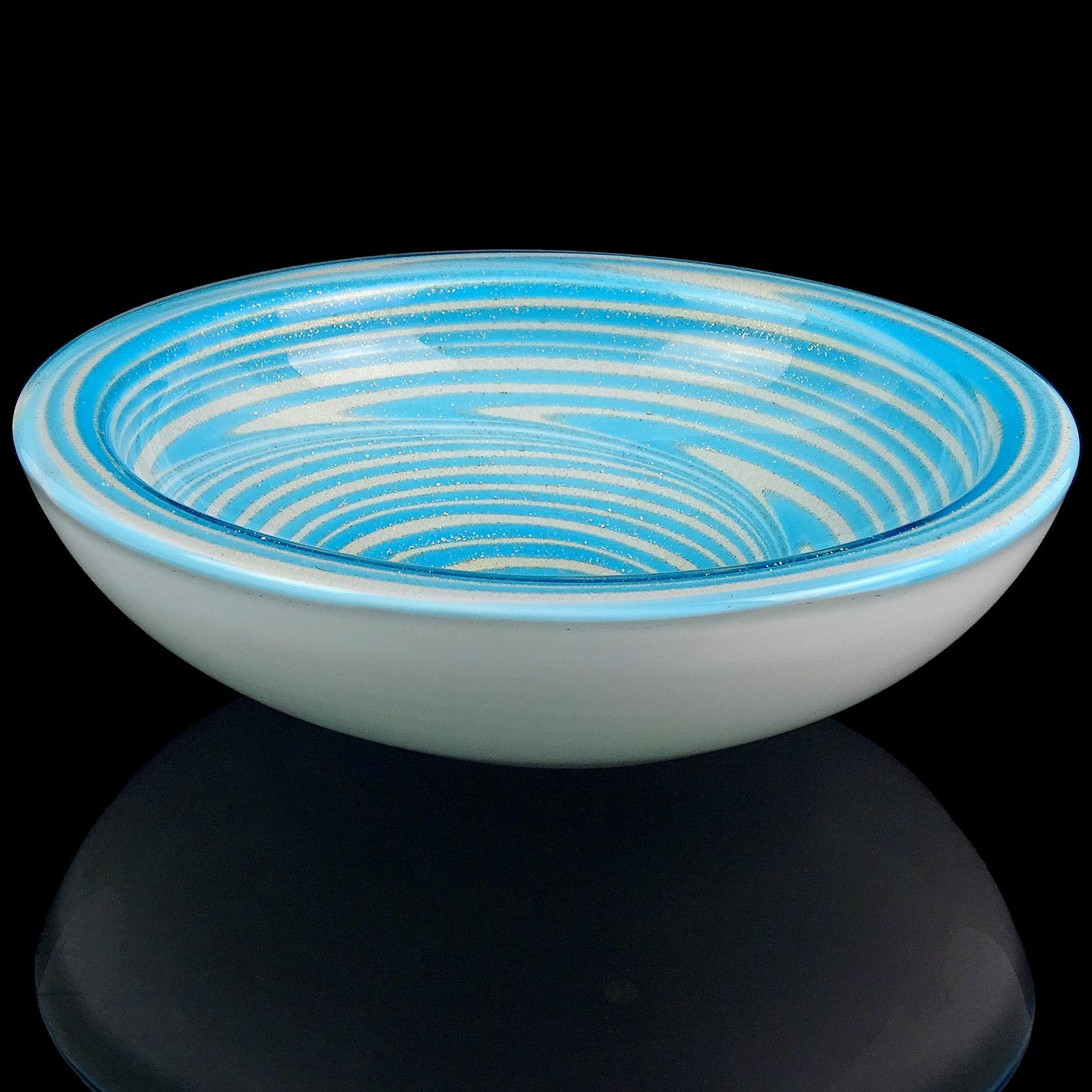 Beautiful Murano handblown sky blue optic swirl and gold flecks Italian art glass bowl. Attributed to the Fratelli Toso Company. Profusely covered in gold leaf on the inside, with psychedelic design. Measures: 7 3/4