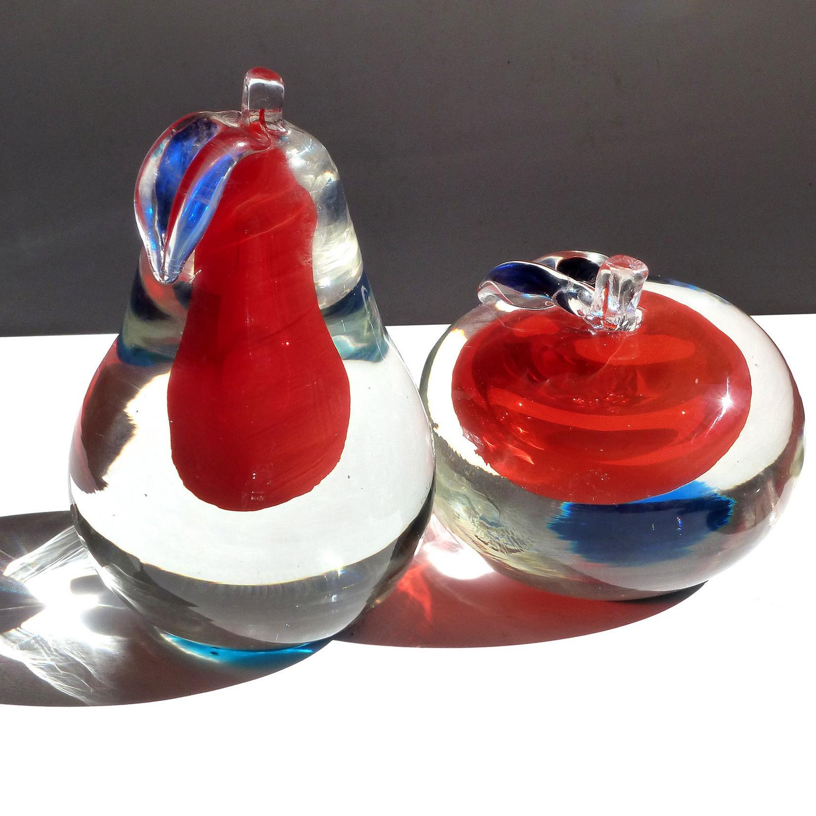 Beautiful set of vintage Murano hand blown Sommerso red, blue and clear Italian art glass apple and pear fruit paperweights. Documented to the Fratelli Toso company. They have a blue circle underneath which reflects on the inside of the fruit. The