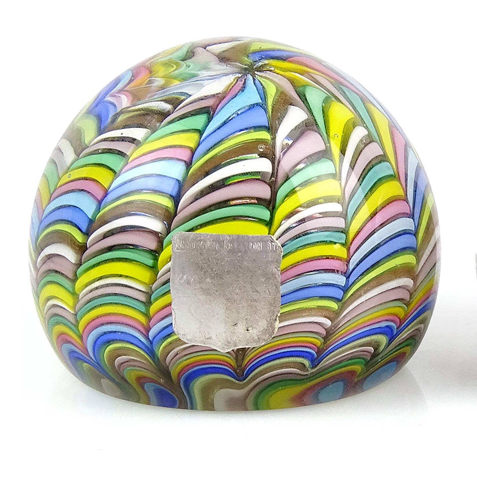 Beautiful vintage Murano hand blown rainbow stripe ribbons Italian art glass paperweight. Documented to the Fratelli Toso Company. It has alternating pink, white, blue, aqua, green, yellow, orange, and copper aventurine stripes. There is a worn