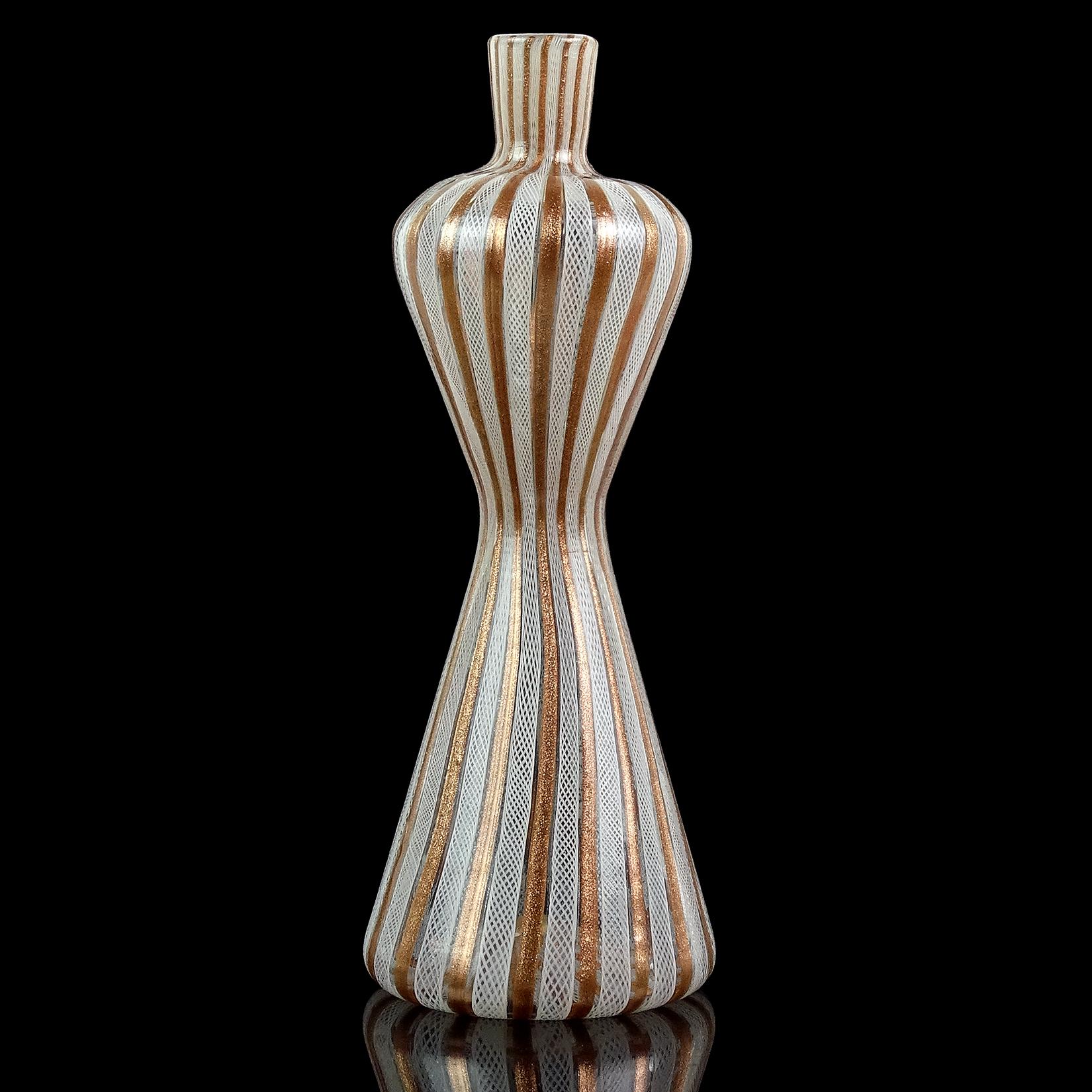 Beautiful and tall, vintage Murano hand blown white Zanfirico ribbons and copper aventurine flecks Italian art glass decorative hourglass corseted vase. Documented to the Fratelli Toso company. The piece still retains an original blue and silver
