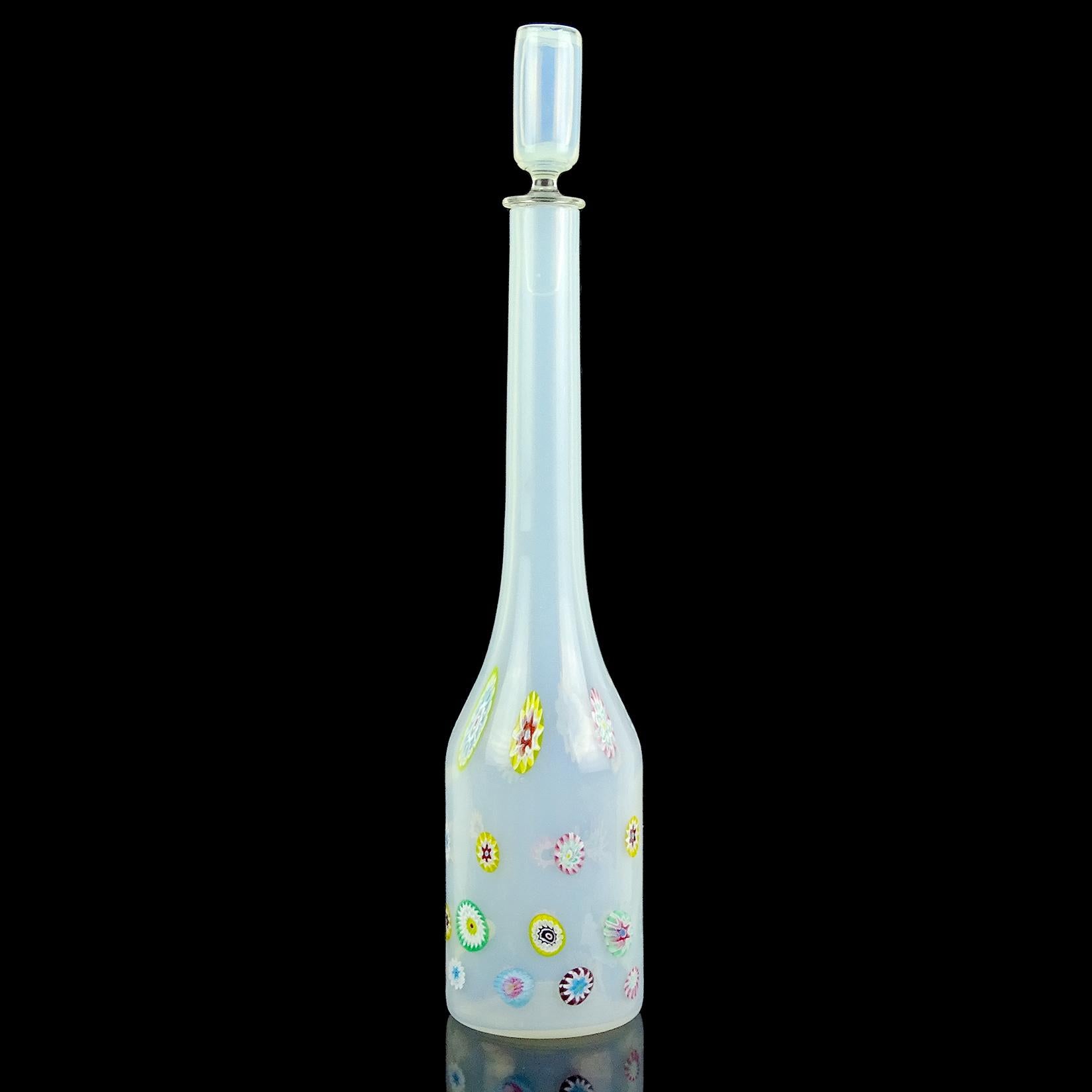 Beautiful vintage Murano hand blown opalescent white with rainbow color flower murrines Italian art glass decanter. Documented to the Fratelli Toso company. Retains the original stopper. The piece has orange, white, blue, yellow, green, purple