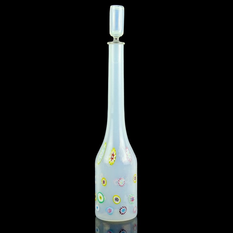 Beautiful vintage Murano hand blown opalescent white with rainbow color flower murrines Italian art glass decanter. Documented to the Fratelli Toso company. Retains its original stopper. The piece has orange, white, blue, yellow, green, purple