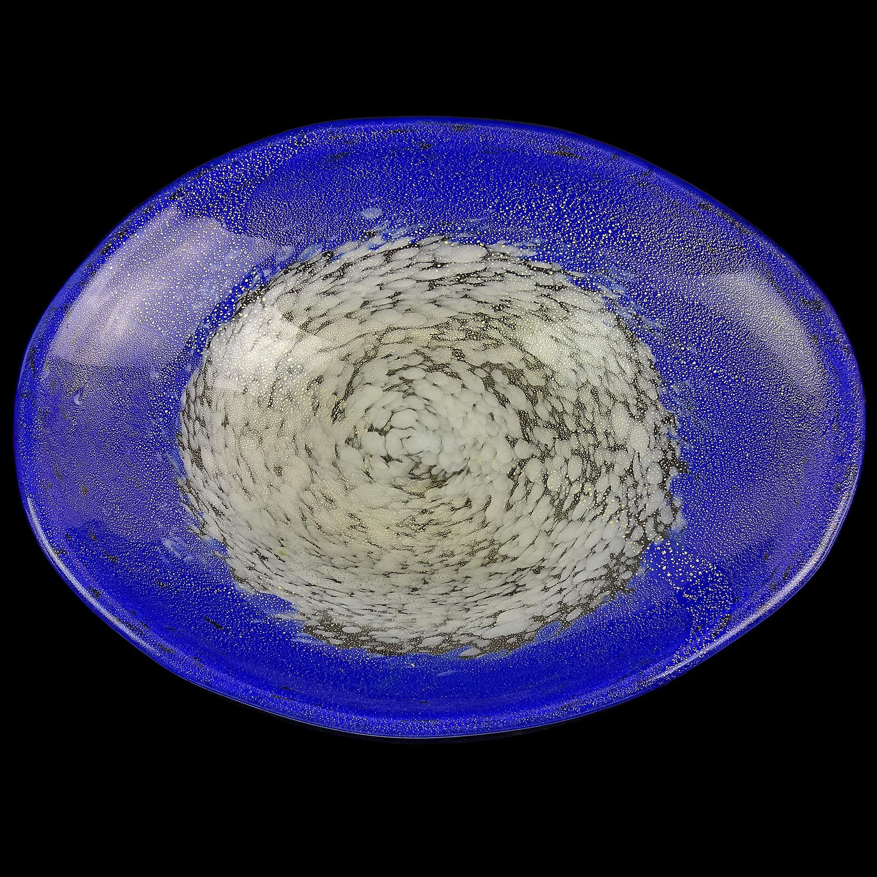 Magnifique bol décoratif en verre d'art italien de Murano, soufflé à la main, blanc avec bord bleu saphir et mouchetures d'or. Attribué à la société Fratelli Toso. La pièce a une forme ovale, et les couleurs sont réalisées avec des milliers