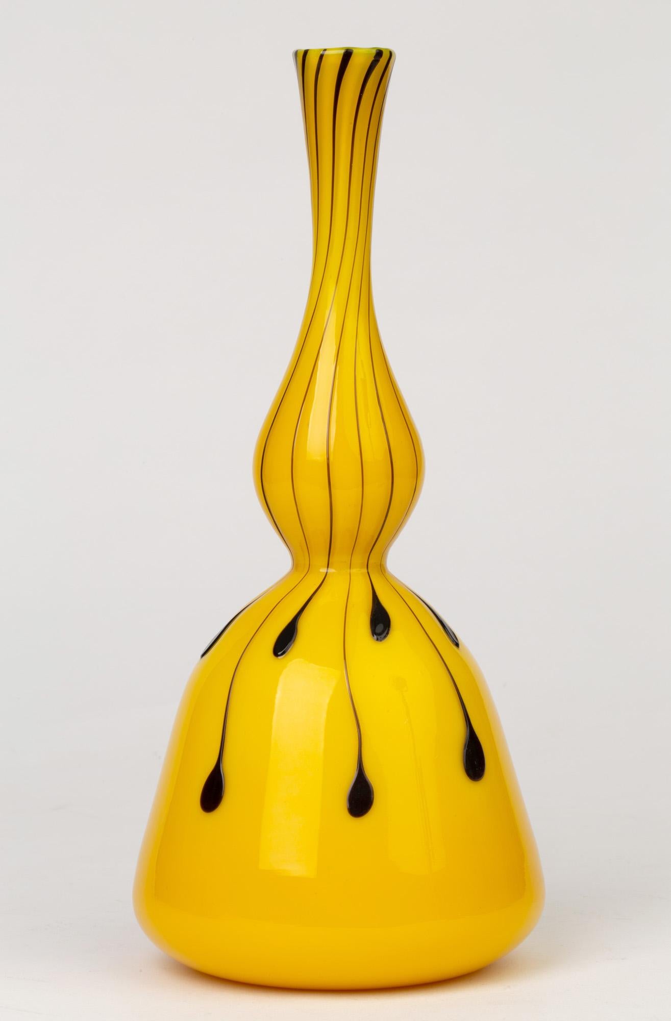 A stunning Italian Murano hand blown art glass vase in cased yellow glass with applied purple glass droplets attributed to Fratelli Toso and dating from circa 1950. The mallet shaped vase has a wide rounded base with a narrow tall elegant neck with