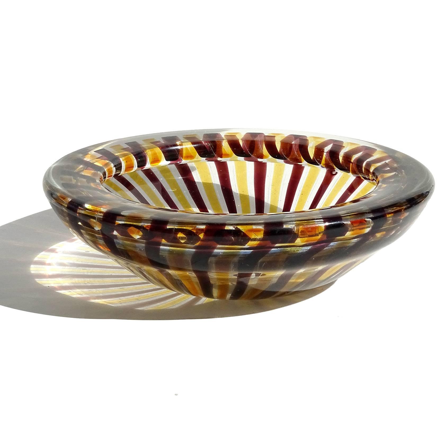 Beautiful Murano hand blown yellow and wine purple ribbons Italian art glass bowl.
Documented to the Fratelli Toso company. The piece has a folded over rim and pinwheel design. A beautiful statement piece for any table. Measures 7 1/2