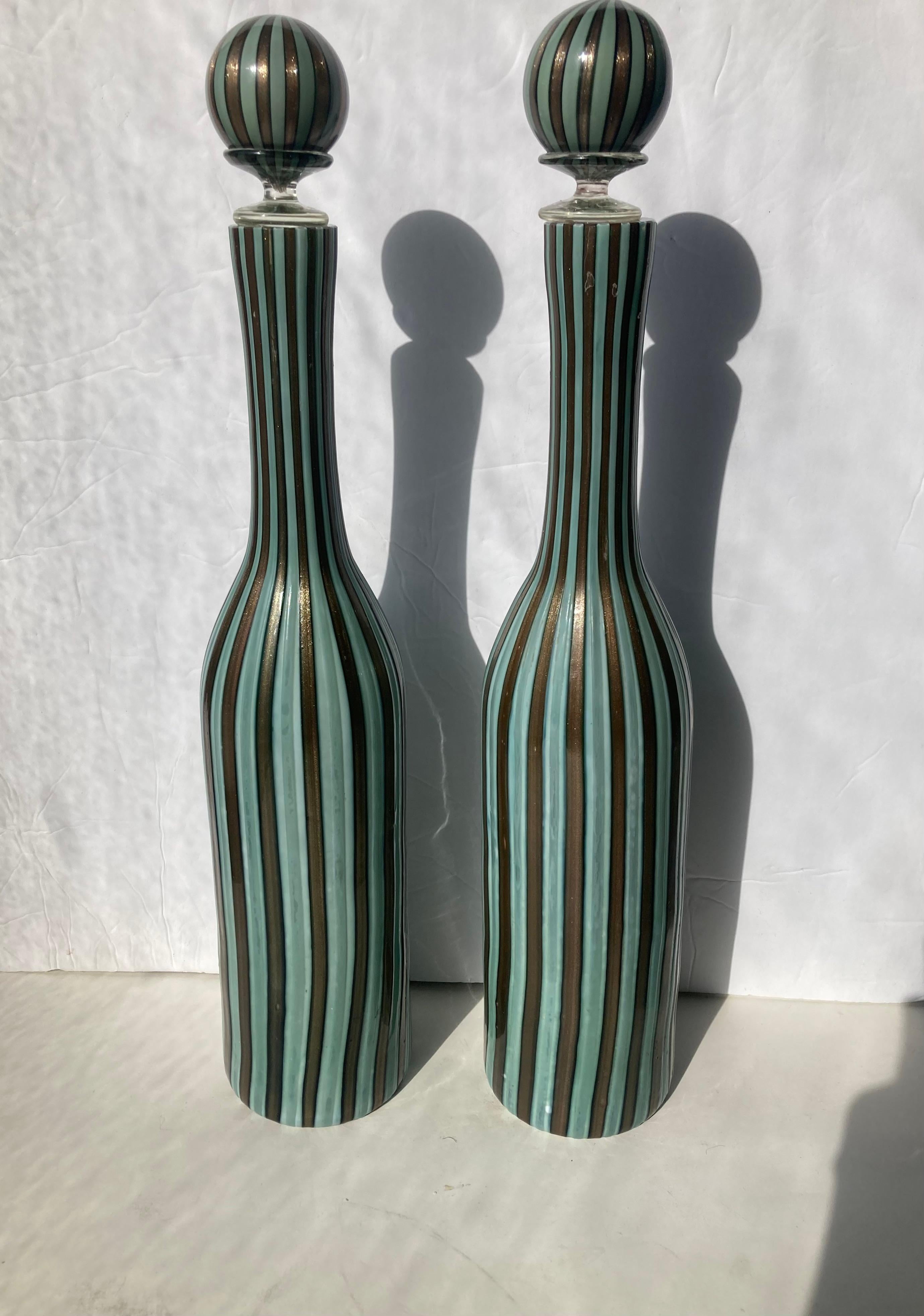 Rare pair of Murano decanters with stopper in this canned glass work. each measures approximately 18 inches high by 3.5 diameter. All Murano like these are hand made and the old saying is 
