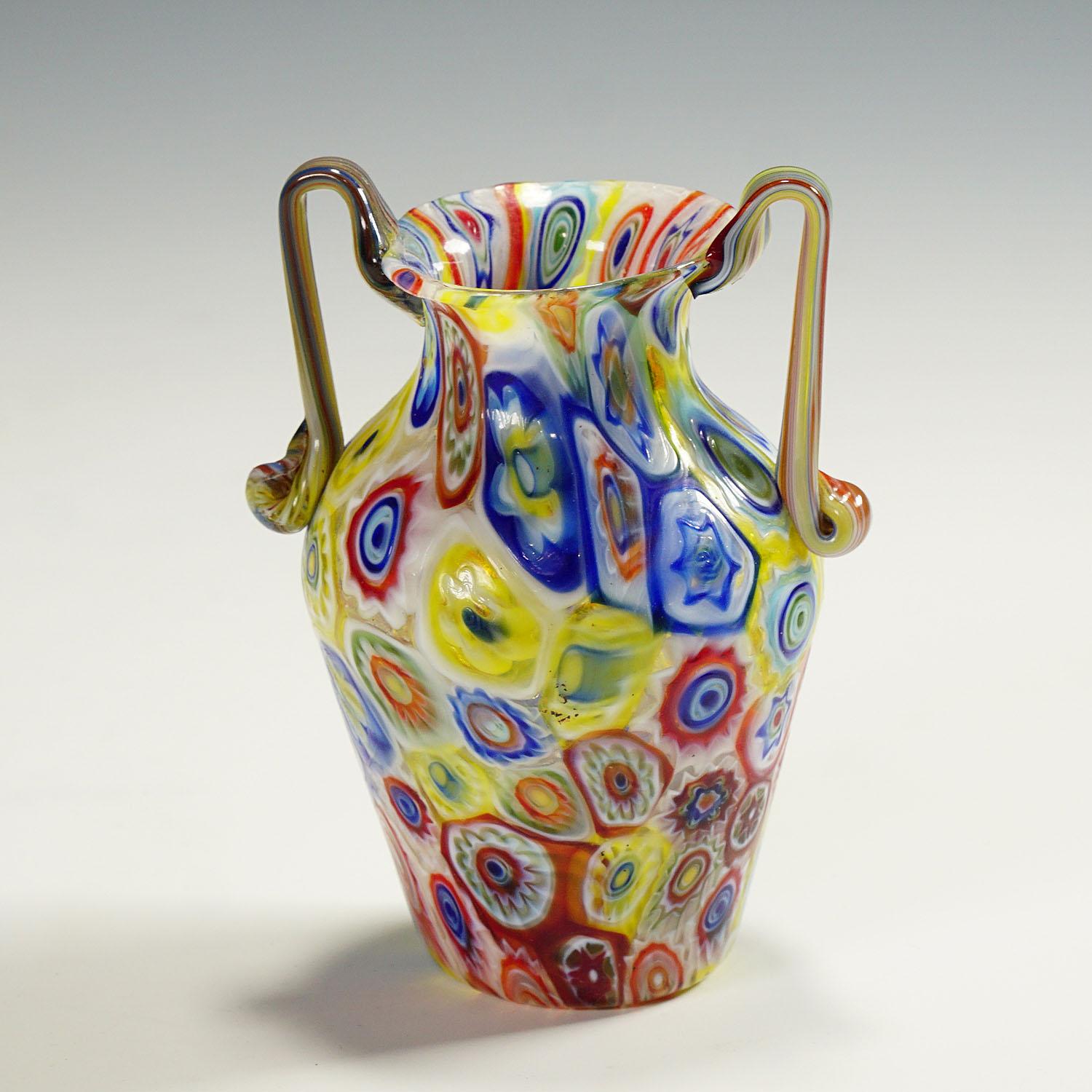 Vase ancien en verre de Murano, fabriqué par Vetreria Fratelli Toso dans les années 1920. Le vase à deux mains est exécuté en verre fin avec des millefiori multicolores et translucides. Contrairement à la plupart des vases Toso millefiori, cet