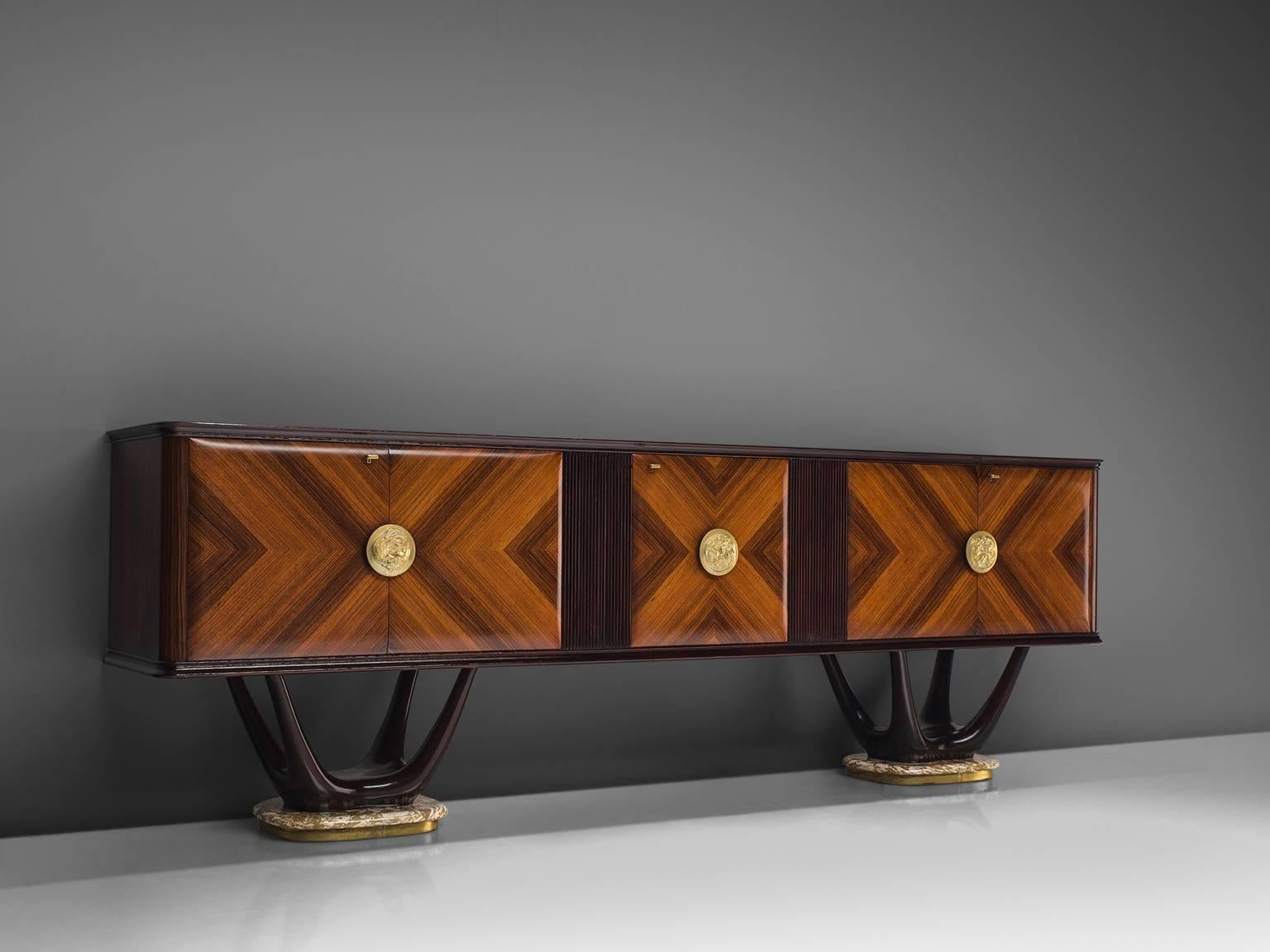 Fratelli Turri, credenza, in mahogany, maple, marble, glass and brass, Italy, 1950s.

This theatrical credenza is designed in the style of Vittorio Dassi. The cabinet itself is made of a mahogany construction. The doors are made of rosewood veneer,