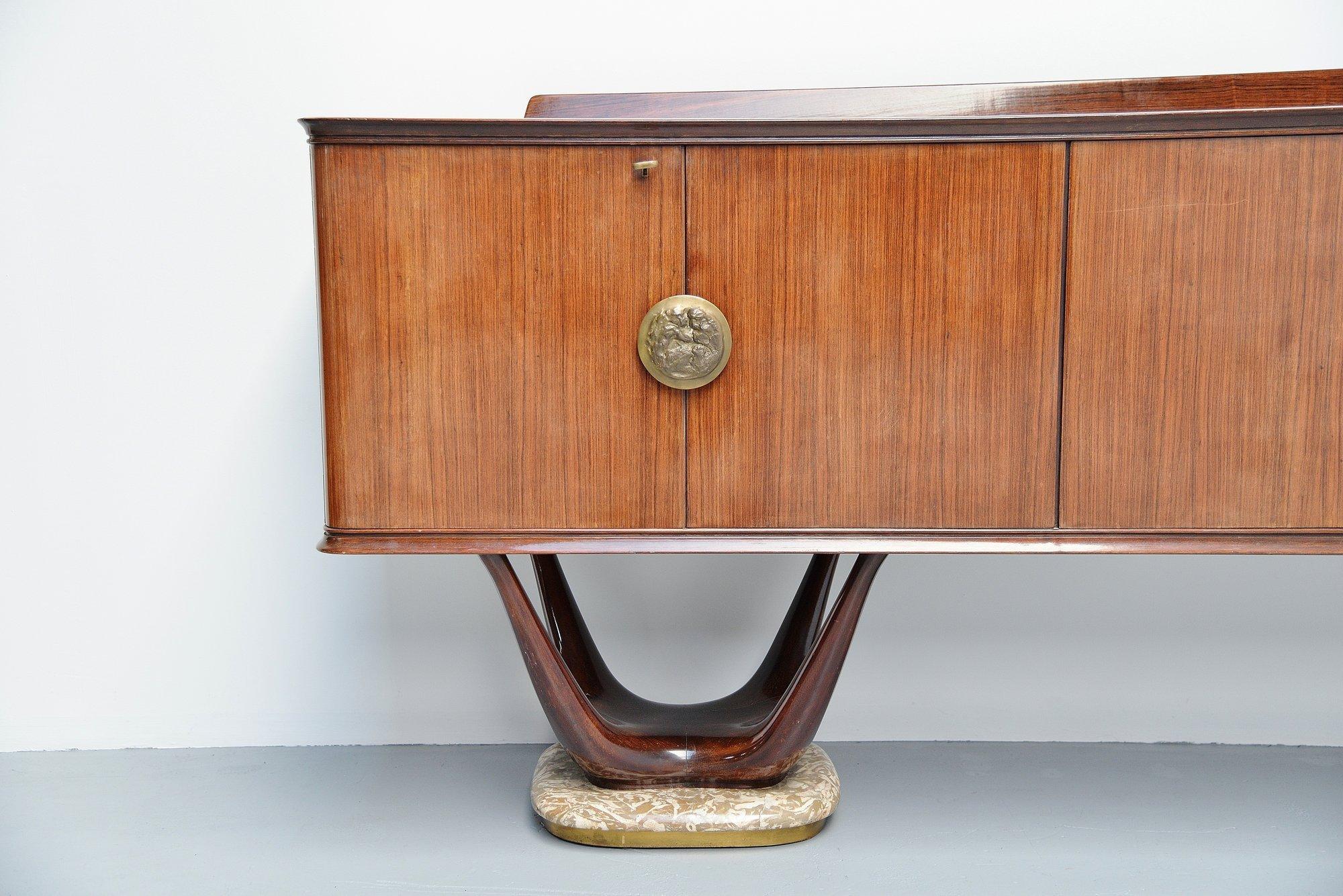 Very impressive long sideboard designed by Fratelli Turri, Italy, 1950. This sideboard in the style of Vittorio Dassi has a nice rosewood casing, rests on 2 mahogany bases with onyx feet and brass rim. The top is covered with painted glass. This