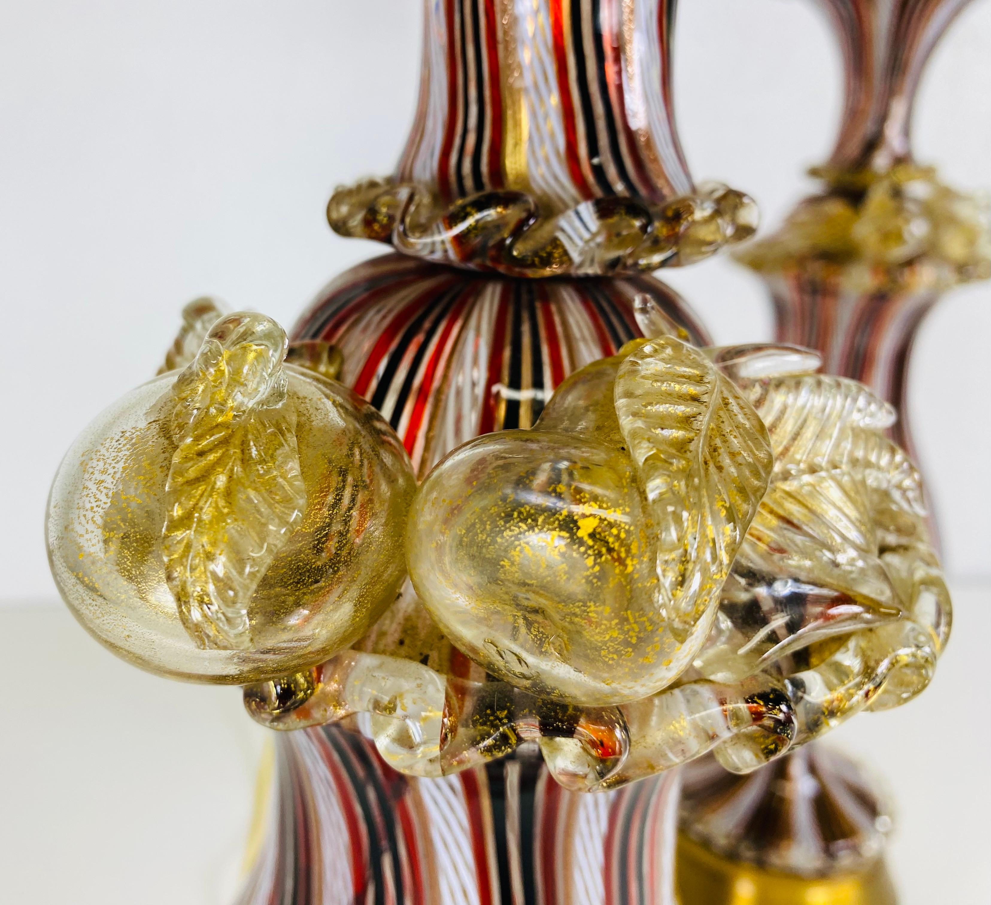 Dies ist ein Paar mundgeblasene italienische Murano Tischlampen von Fratelli Toso. Dieses überdimensionale Lampenpaar ist mit mundgeblasenen schwarzen, burgunderroten und goldenen Bändern versehen. Die Lampen sind oben mit mundgeblasenem Glas mit