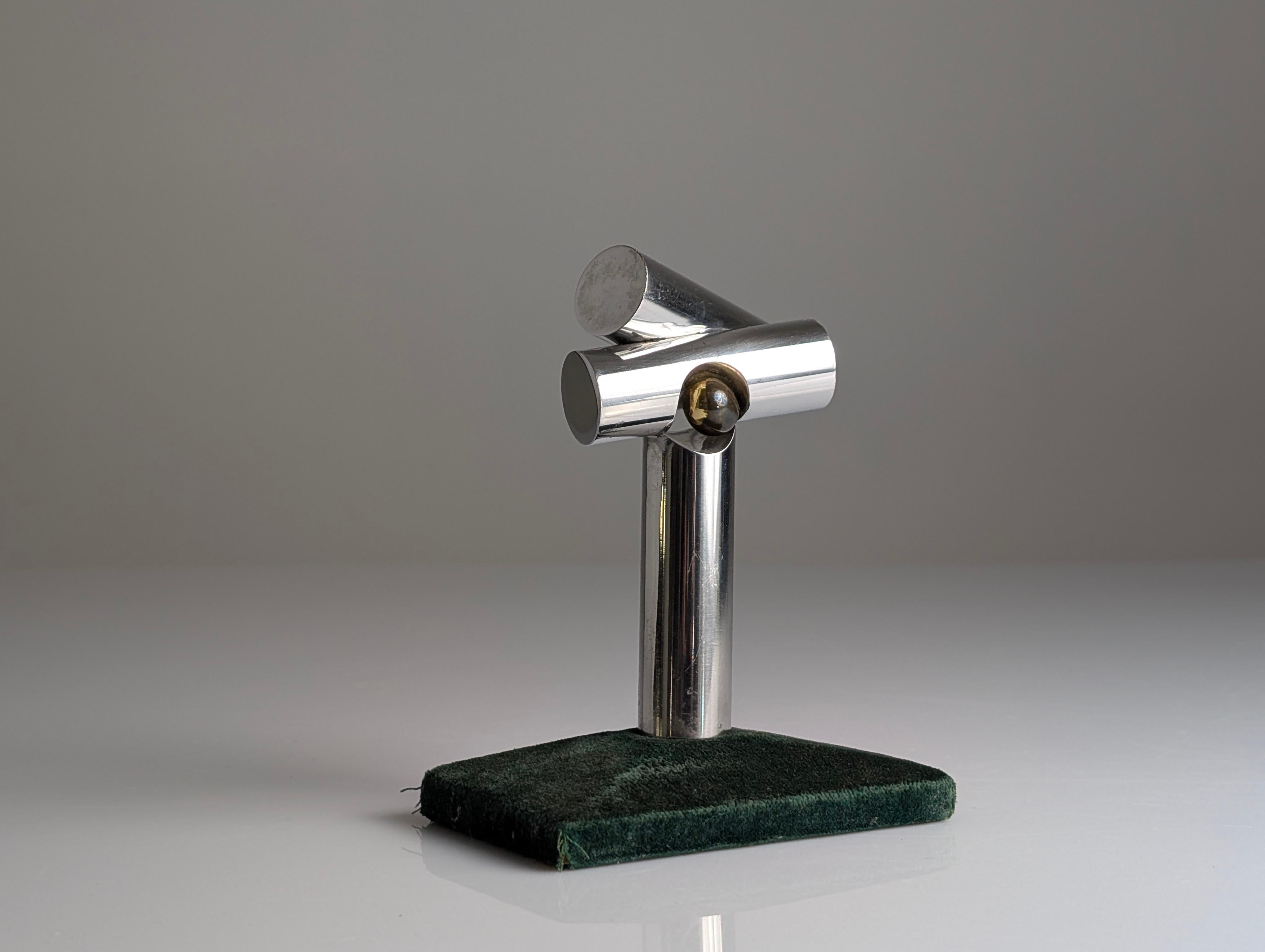 Scultura intitolata Composición de Tubos y esfera de bronce (Composizione di tubi e sfera di bronzo) dell'artista spagnolo Lorenzo Frechilla (1927-1990). Questo pezzo è un esempio convincente di scultura astratta modernista degli anni '70, che