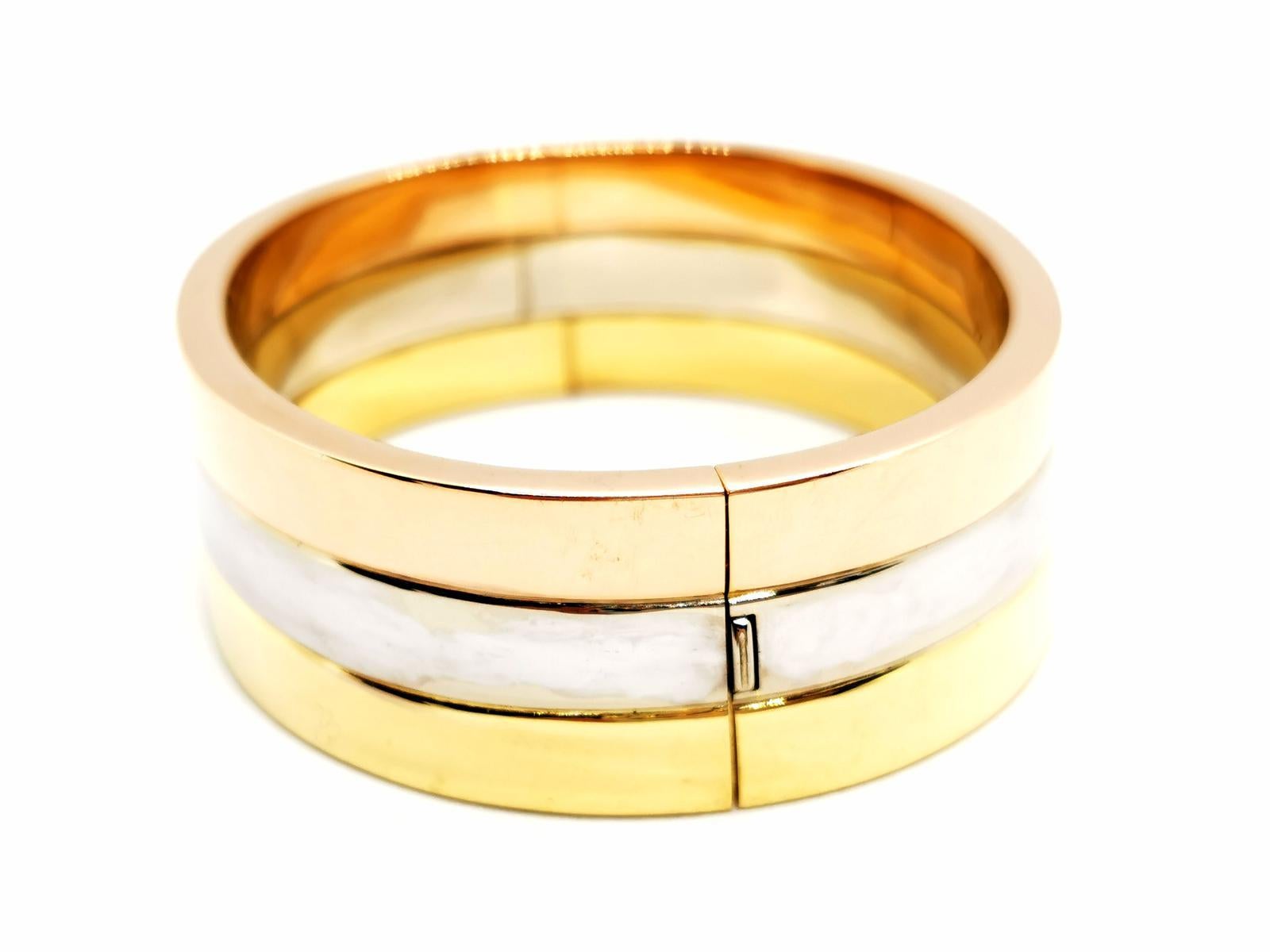 Starres Manschettenarmband. signiert von Maison Fred. aus 750 Tausendstel Gold (18 Karat). Roségold. Gelbgold und Weißgold. ovale Form. Größe: 17,5 cm. Breite: 2,03 cm. Dicke: 0,35 cm . Innendurchmesser: 5,8 cm x 4,8 cm. Gesamtgewicht: 65,45 g.