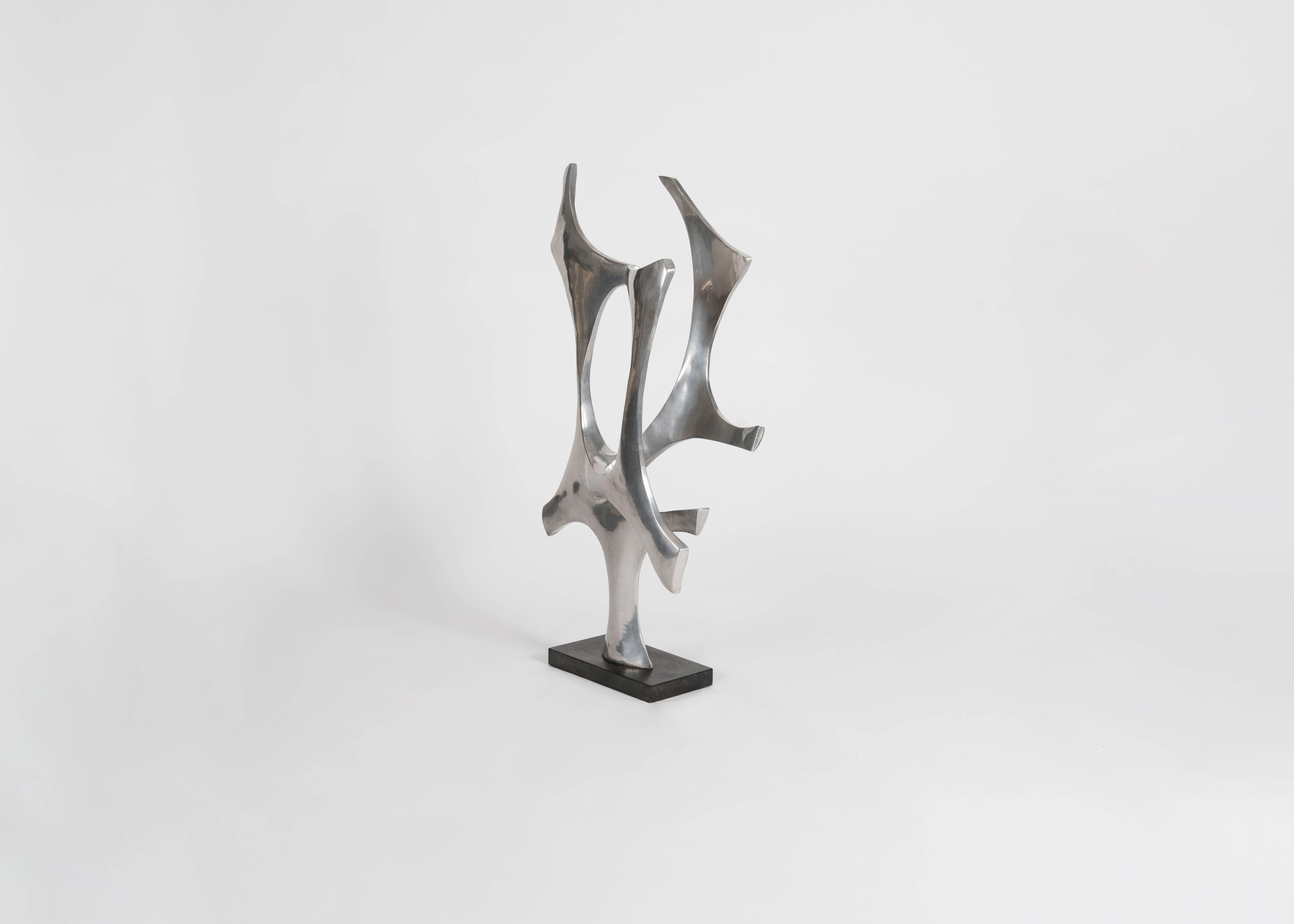 This piece in polished aluminum, elevated on a rectangular, black pedestal, by Fred Brouard, illustrious and groundbreaking French sculpture and furniture maker of the mid-to-late twentieth century, is singular and remarkable for its size and