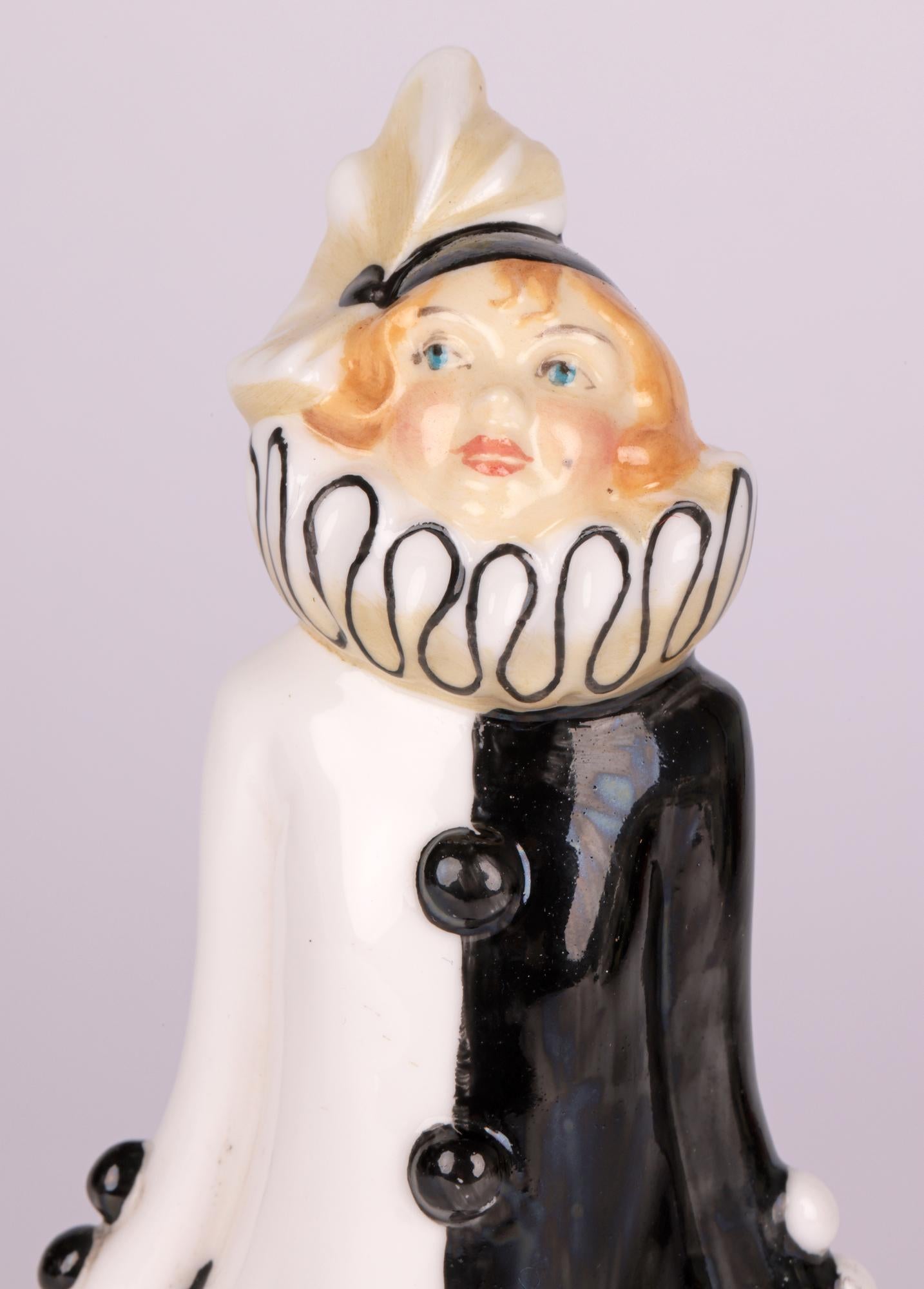Rare figurine en porcelaine Art Déco de Minton intitulée Pierette, conçue par Fred Cooke et datant d'environ 1930. Cette ravissante figurine debout est montée sur un étroit socle rond et est habillée d'un costume de clown avec de grandes manchettes