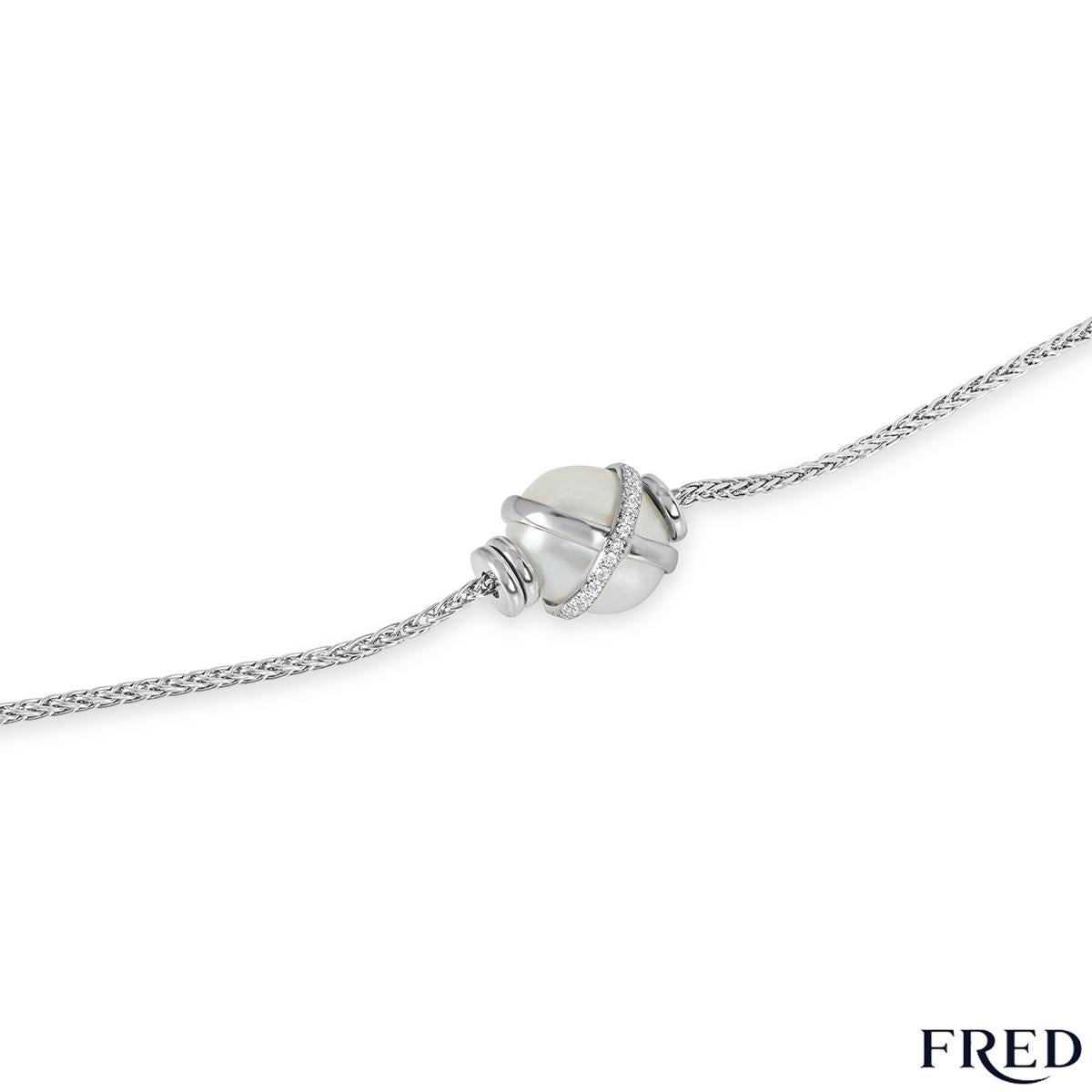 A beautiful diamond and pearl bracelet in platinum from the Baie Des Anges collection by Fred. The bracelet is set to the centre with a 10 - 10.5mm white freshwater pearl with a platinum cross over design through the middle. This is half pave set