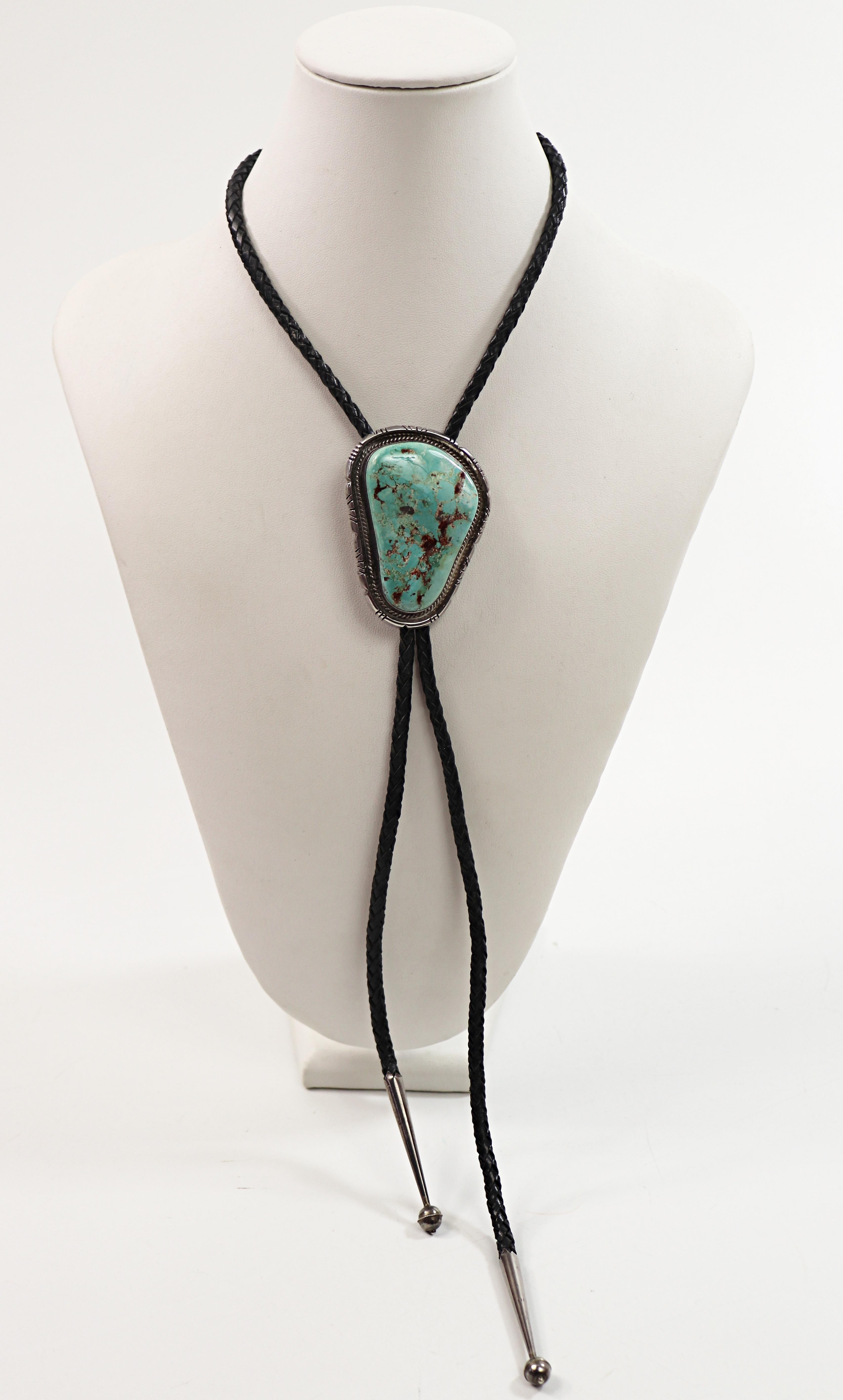 Featuring a beautiful blue turquoise in matrix (stabilized), 55 X 37 mm to
20.9 mm X 9.0 mm, set in a silver notched and wire twist frame mounting,
65.5 X 50.0 mm, with a fold over locking slide, suspended from a 4.5 mm
braided leather tie each end