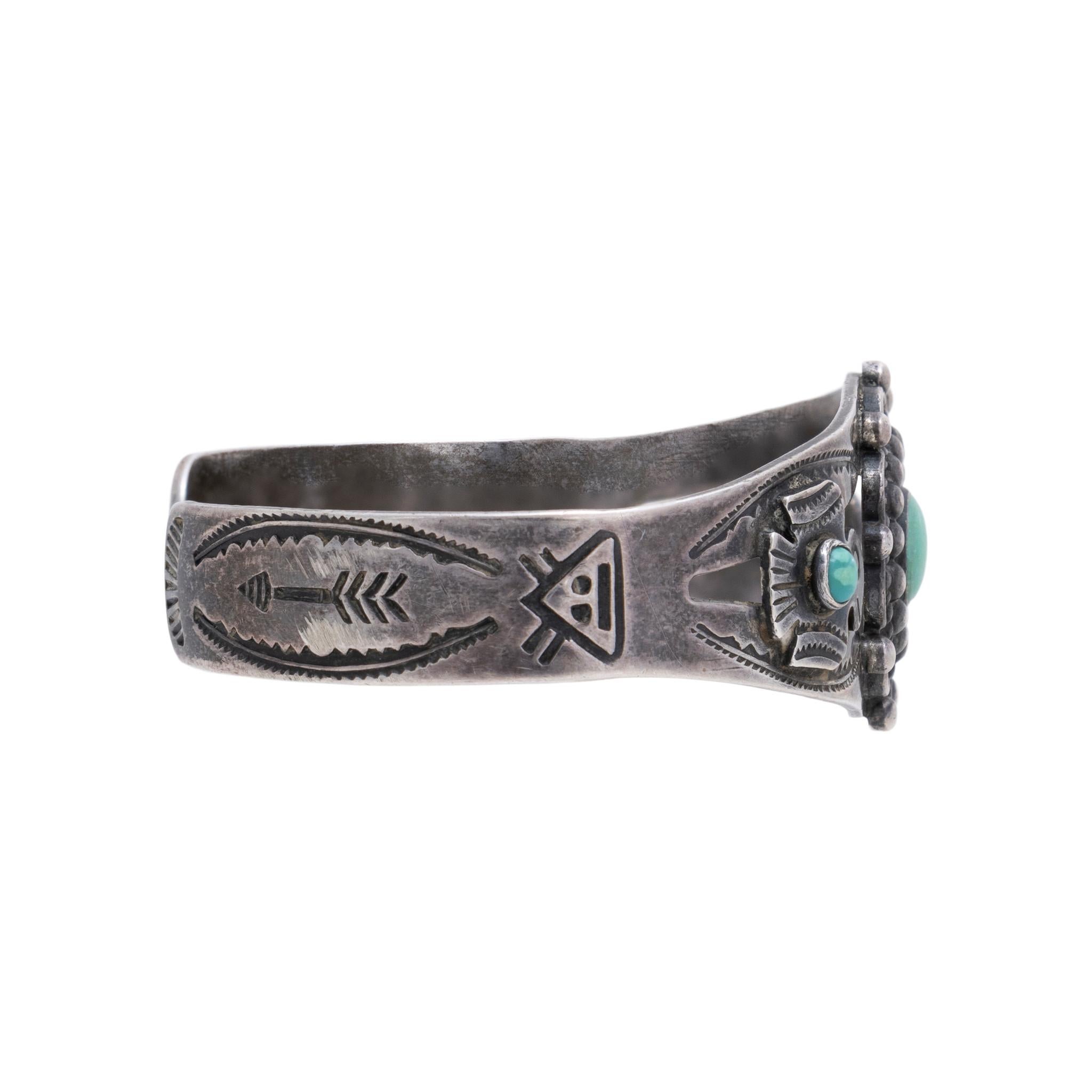 Native American Navajo Indian turquoise and sterling silver Fred Harvey bracelet. This lovely bracelet has three snake-eye turquoise cabochons, surrounded by dainty cutouts, silver thunderbird applique, twisted wire, and hand stamping on the cuff, a